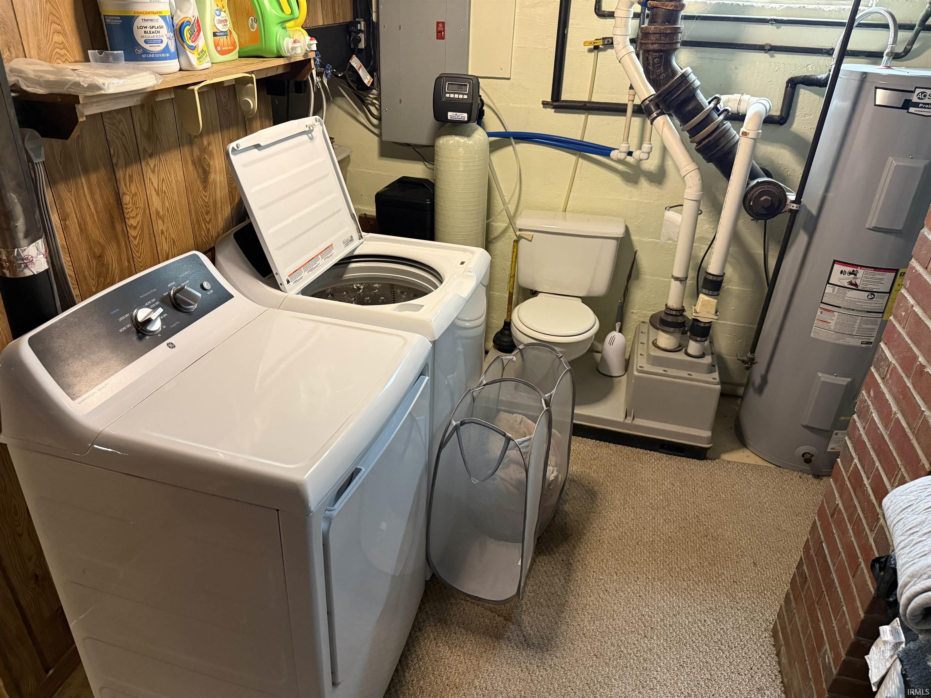 Laundry area with electric water heater, electric panel, and washer and dryer