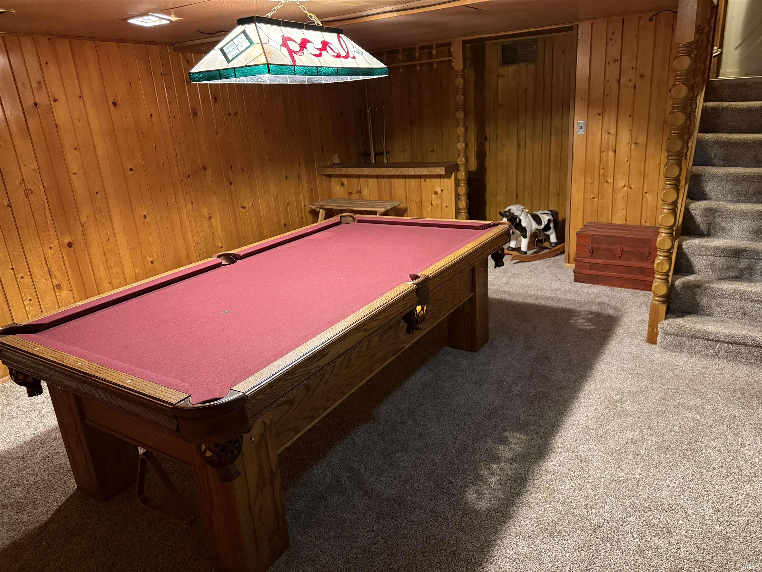Playroom with light carpet, billiards, and wood walls