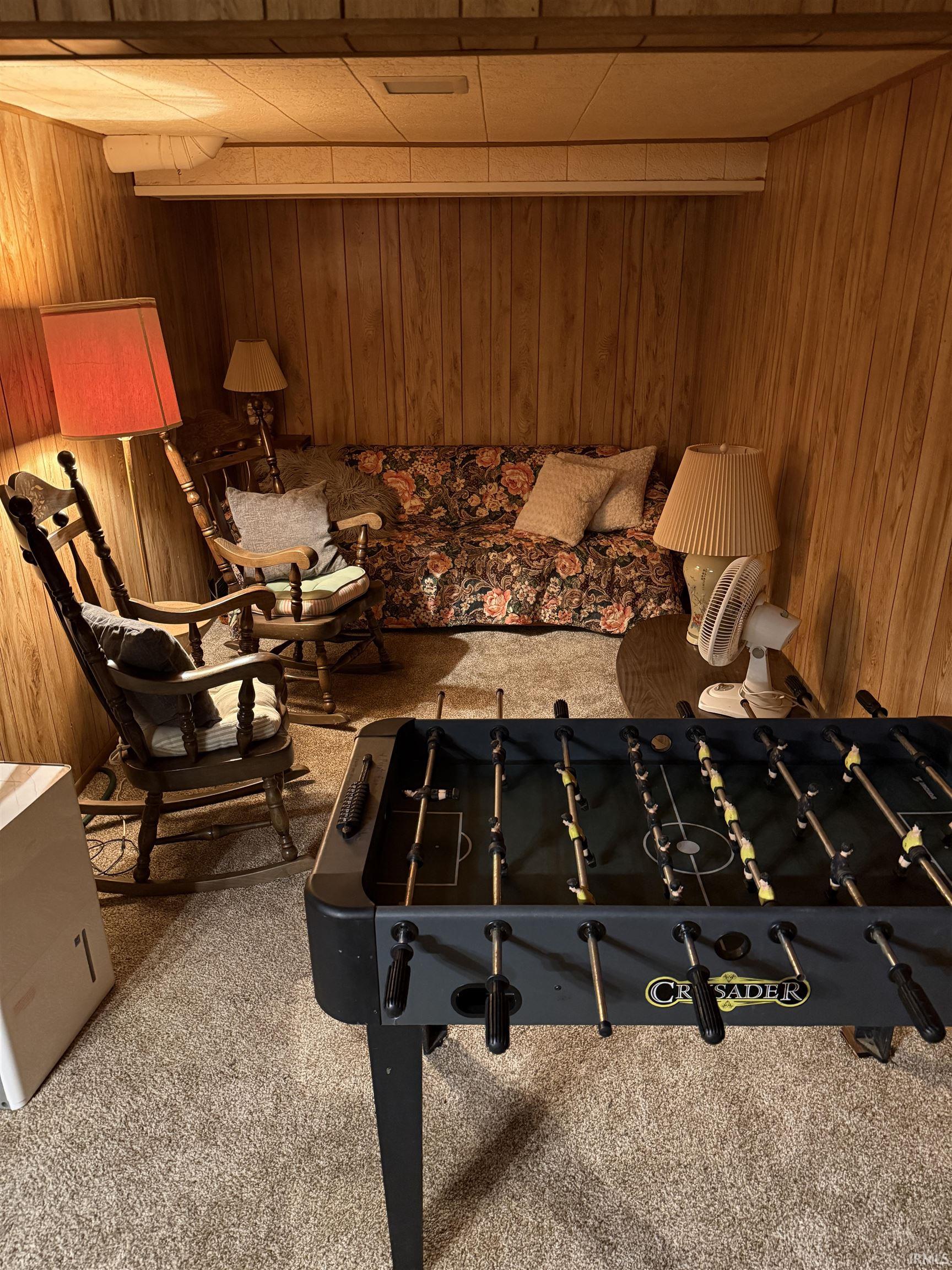 Rec room with carpet floors and wooden walls