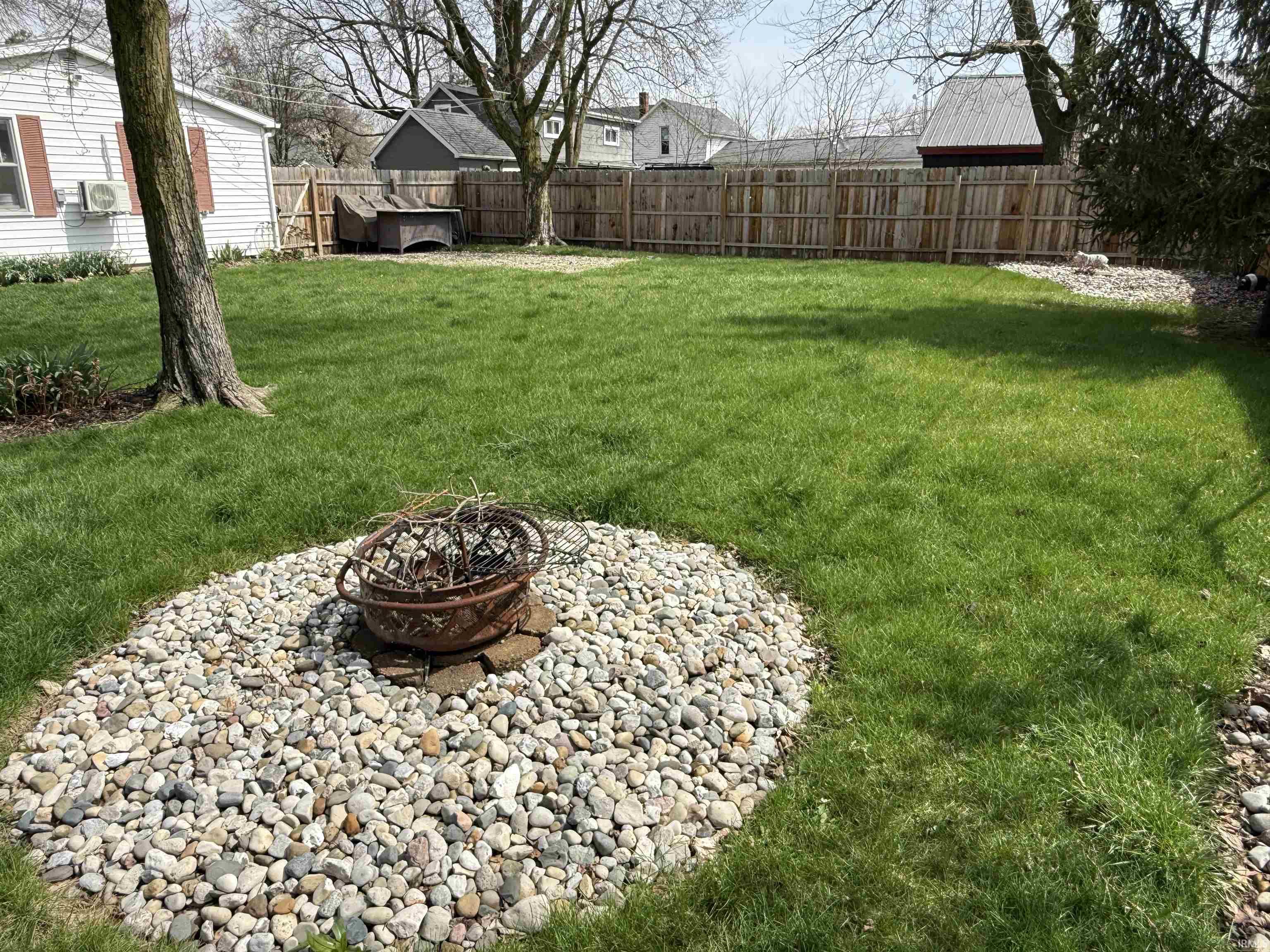 Fenced backyard featuring a fire pit
