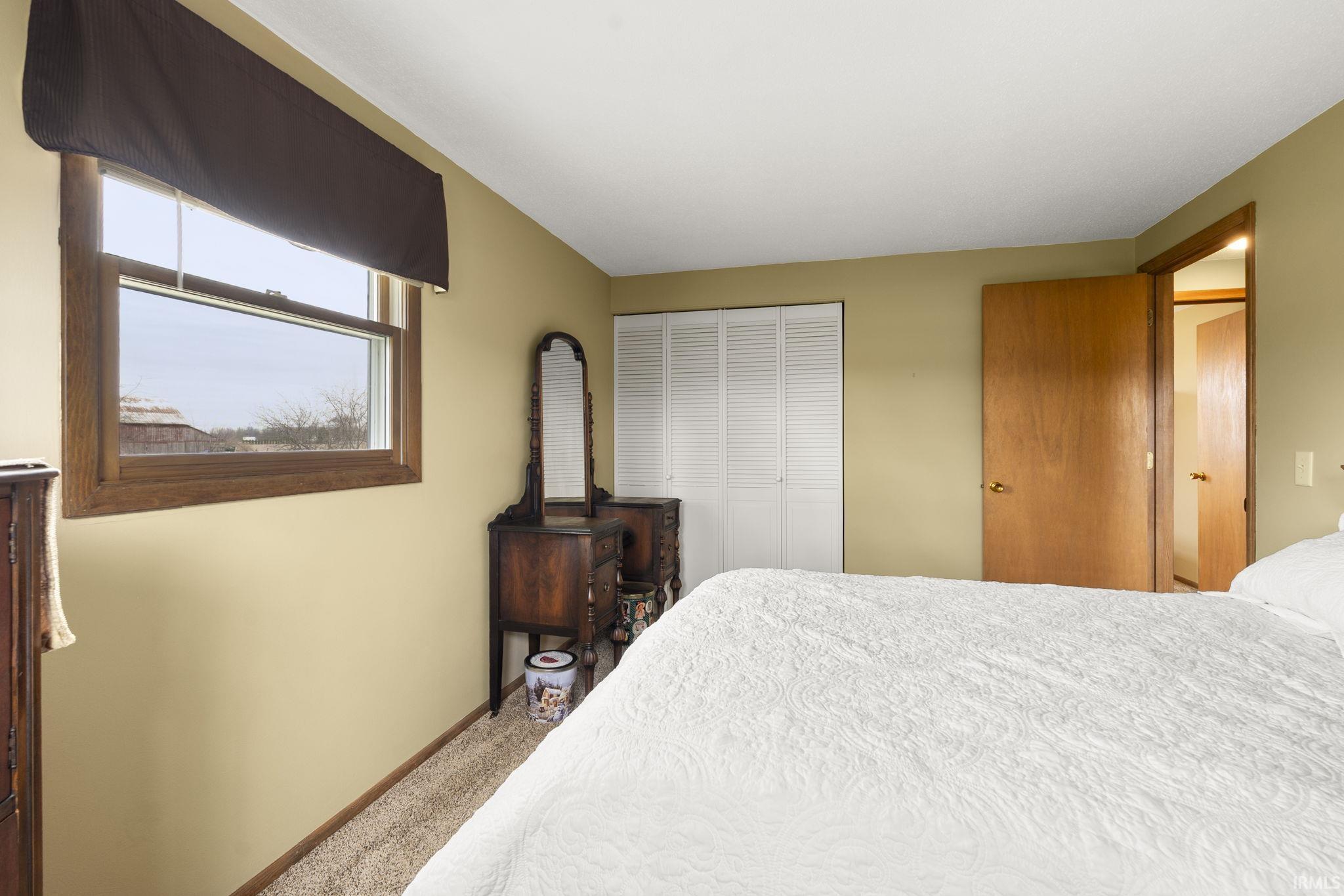Carpeted bedroom featuring baseboards and a closet