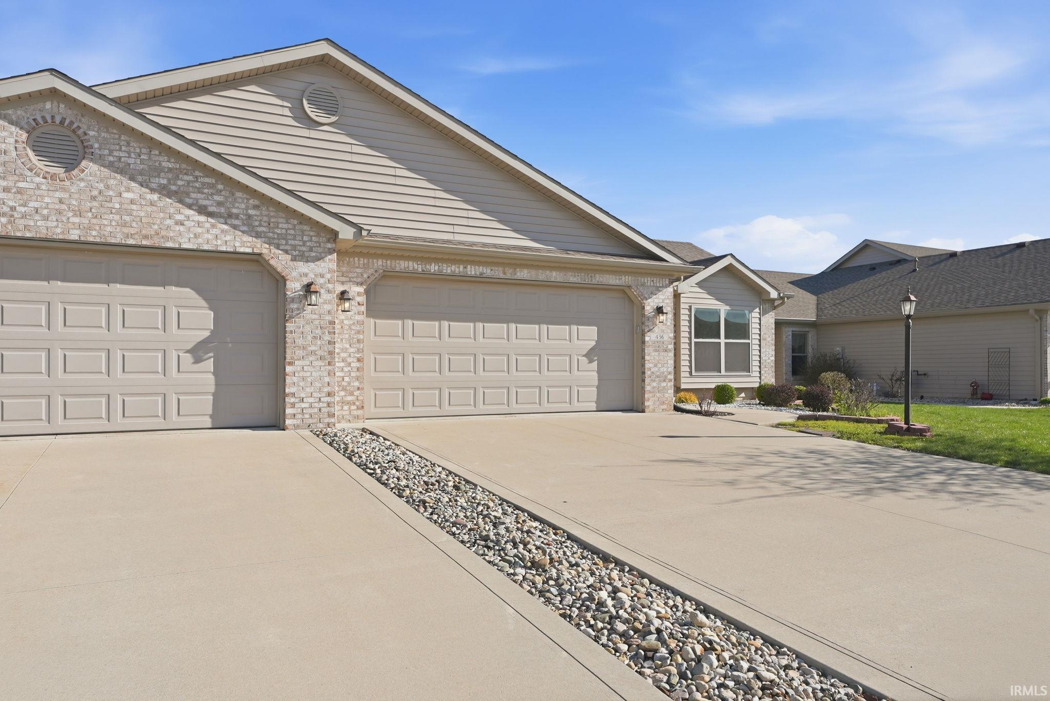 Single story home with brick siding, concrete driveway, and a garage