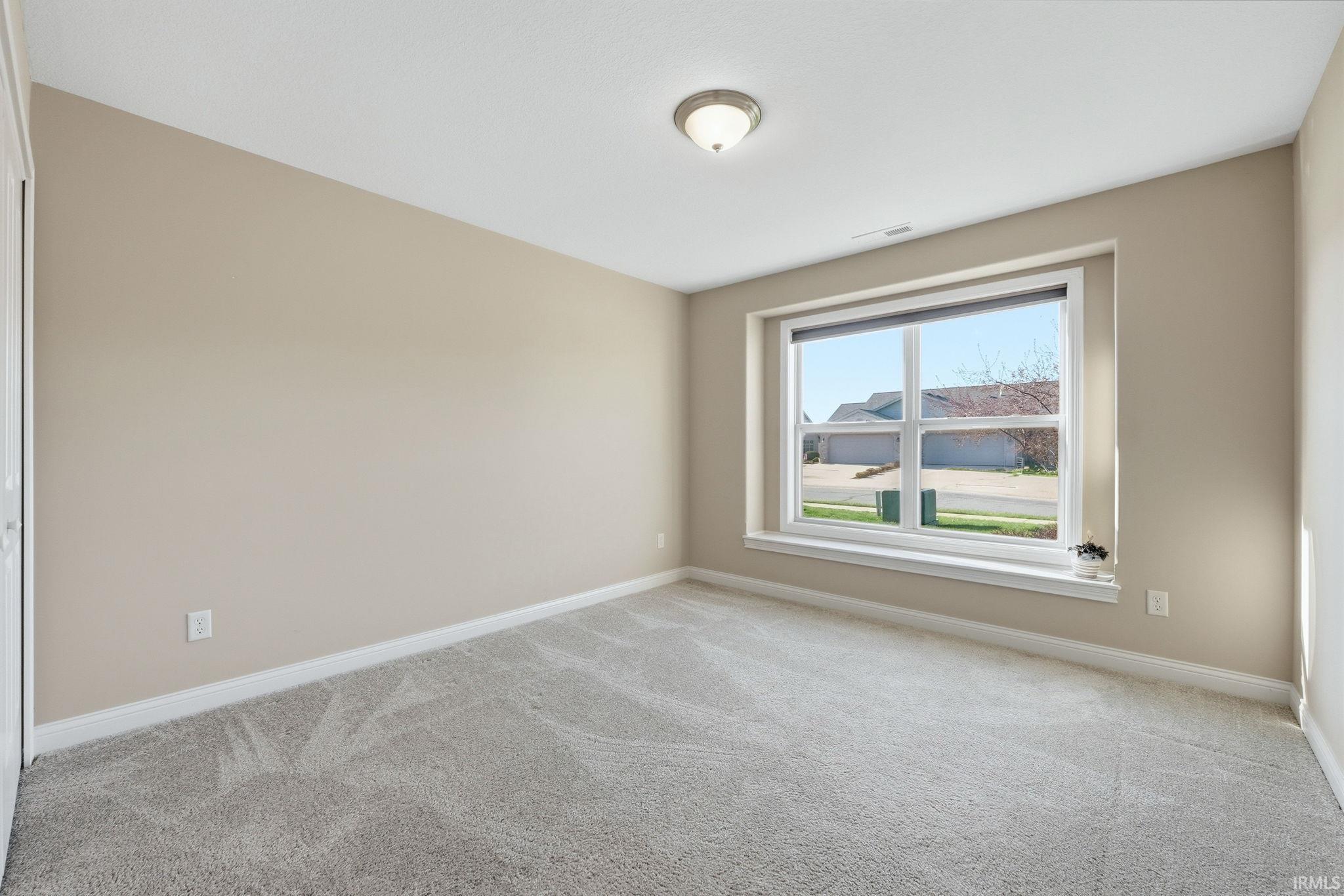 Unfurnished room featuring light colored carpet and baseboards