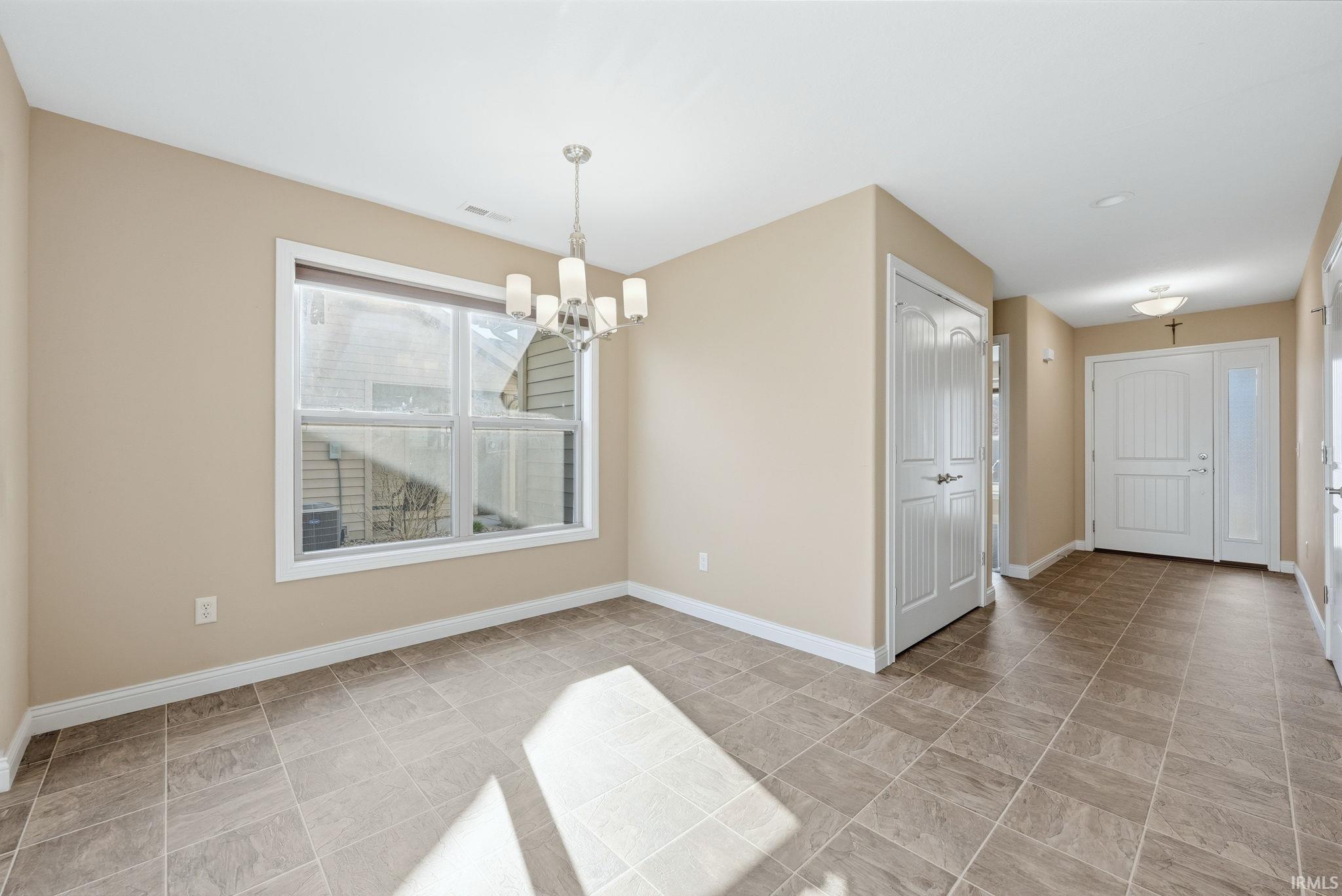Unfurnished dining area featuring hanging lights and baseboards