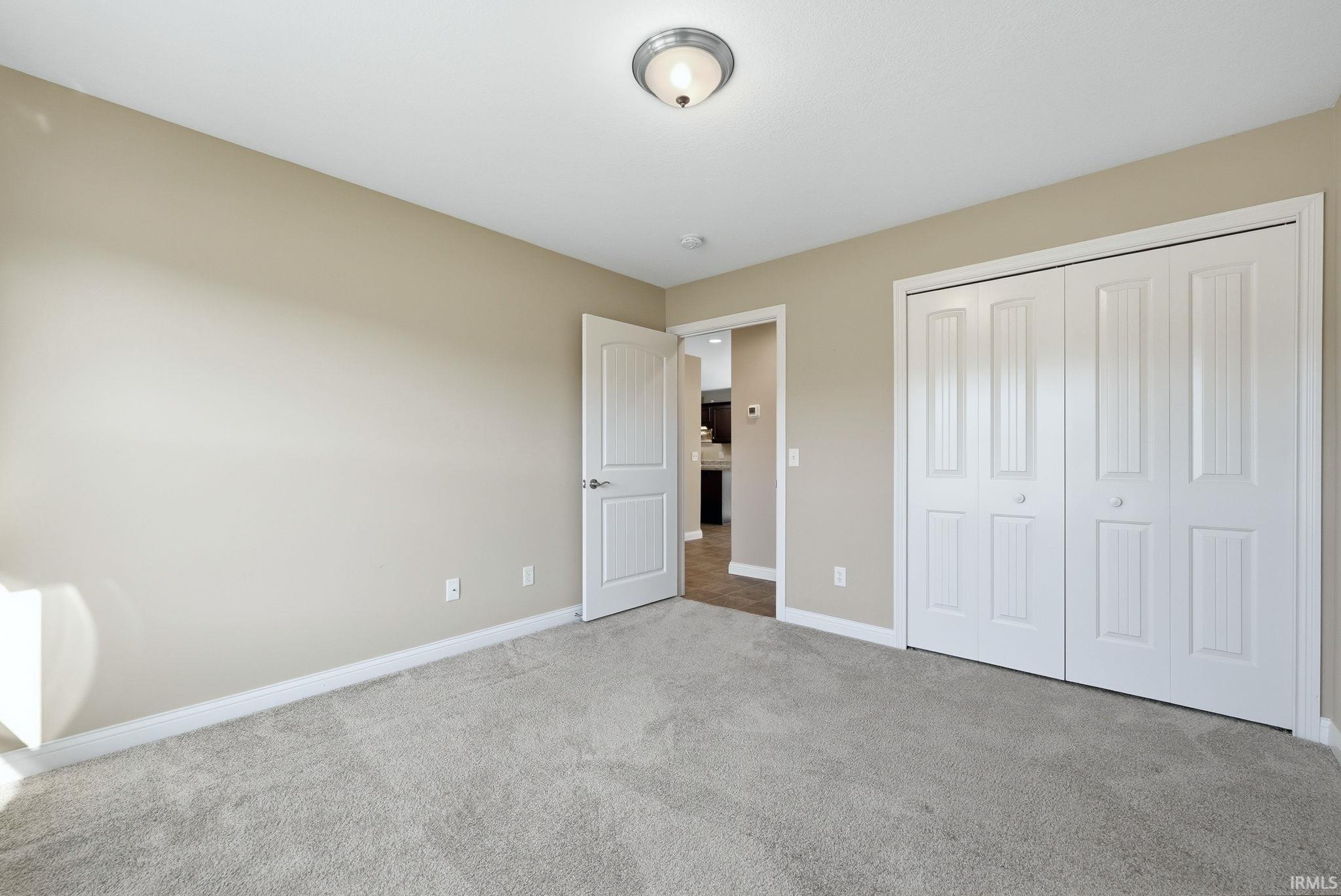 Unfurnished bedroom with carpet and a closet