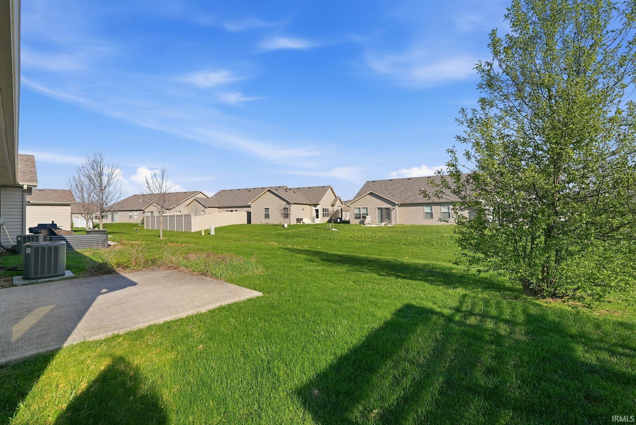 View of green lawn with a residential view and a patio area