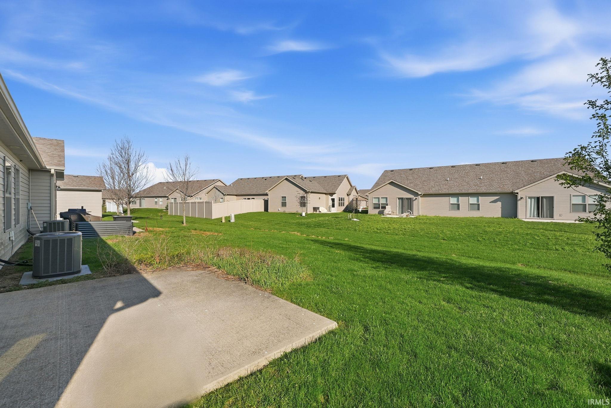 View of green lawn with a patio and a residential view