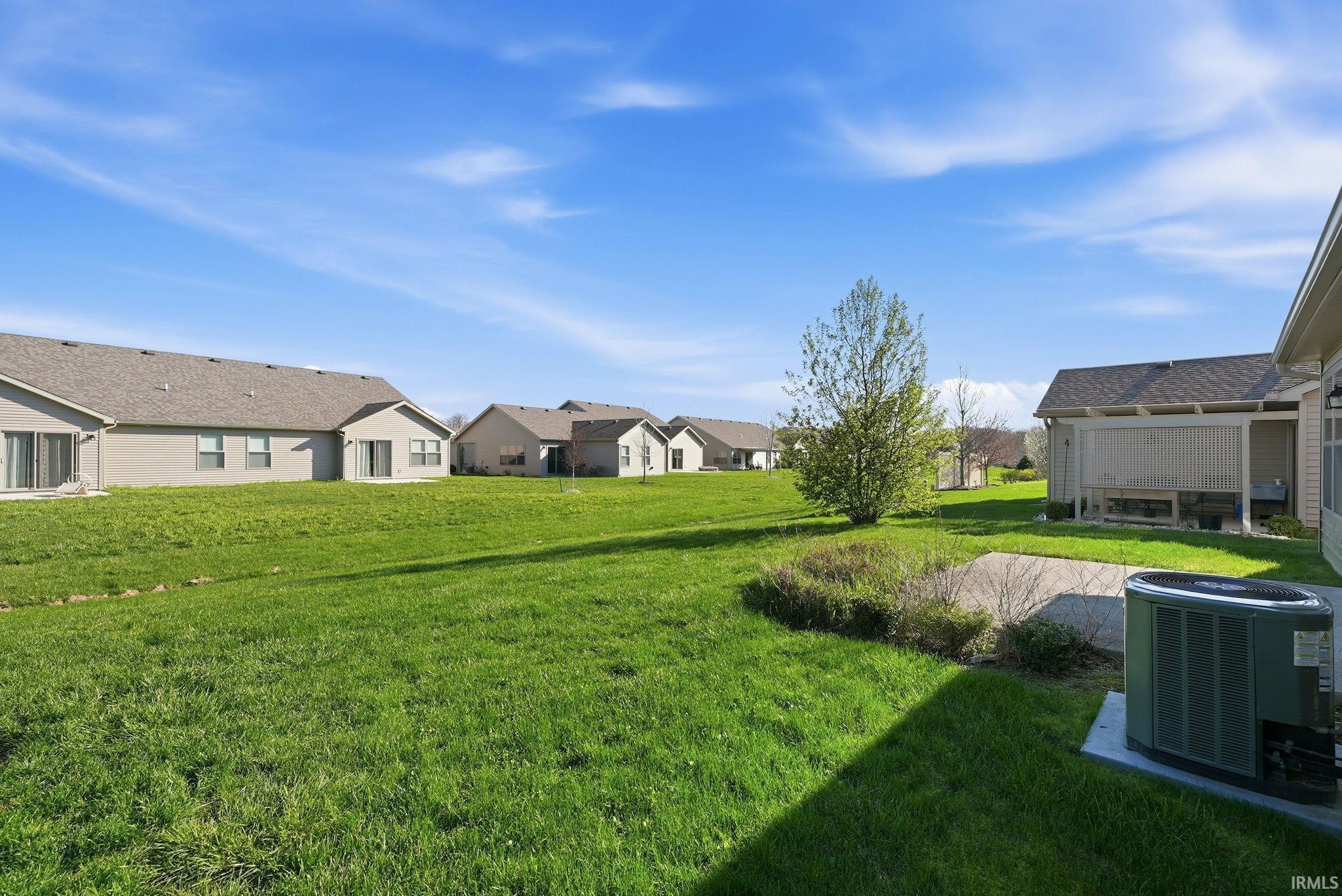 View of grassy yard featuring a residential view and a patio area
