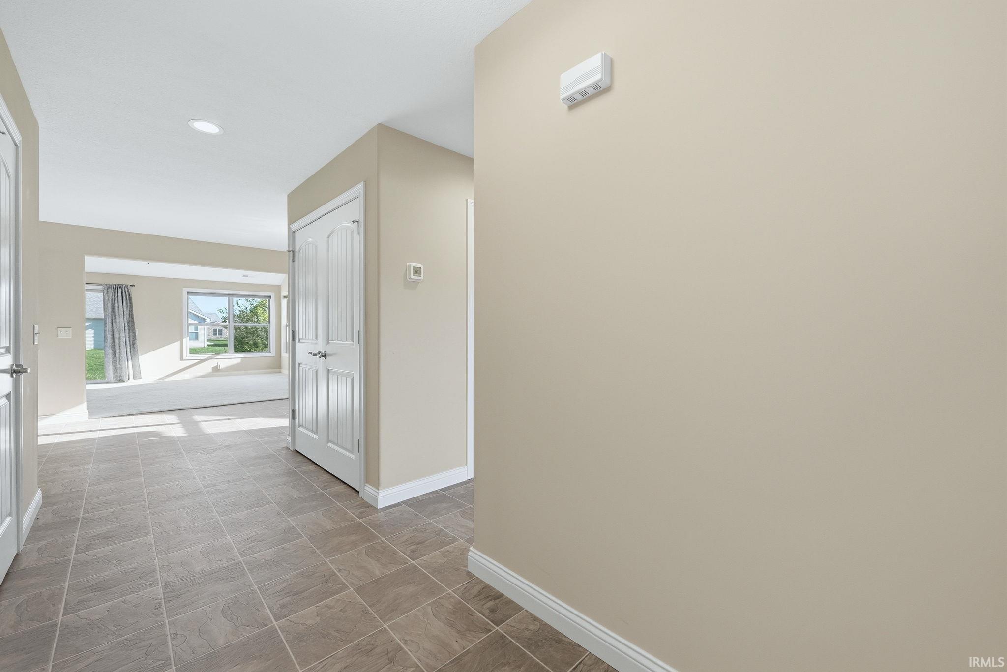 Corridor with baseboards and recessed lighting