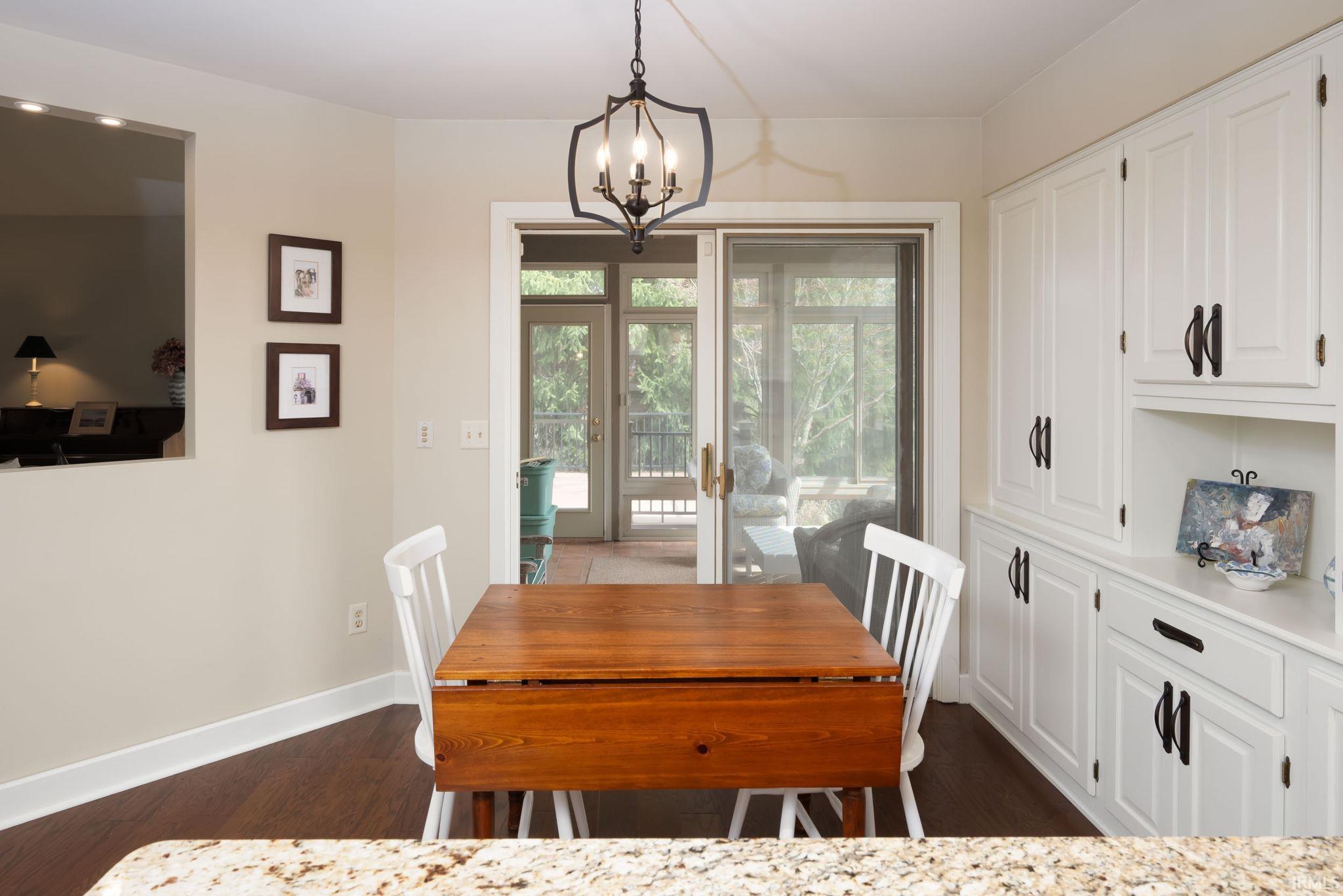 Dining space featuring dark wood-style floors and hanging lights