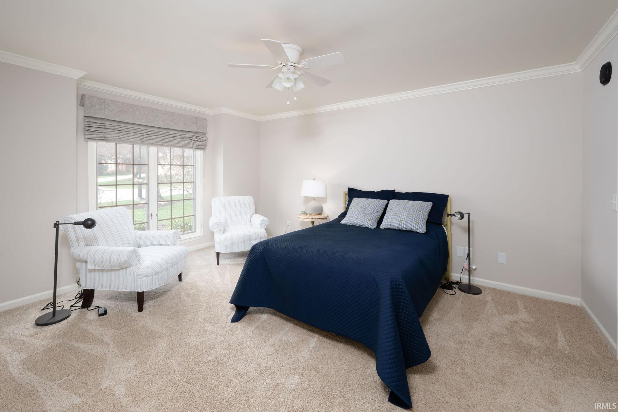 Bedroom featuring crown molding, light colored carpet, and ceiling fan
