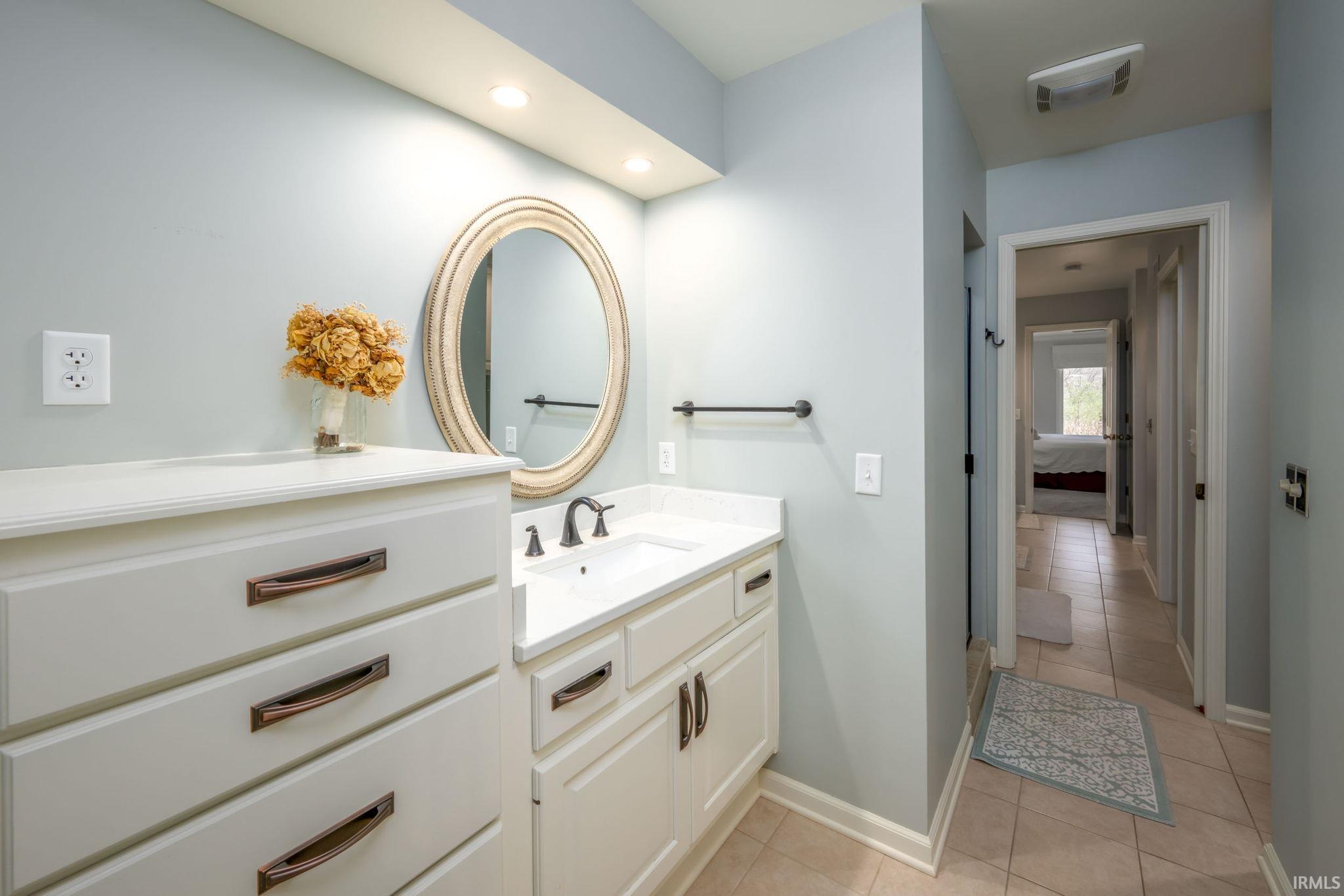 Bathroom featuring vanity, light tile patterned floors, and recessed lighting