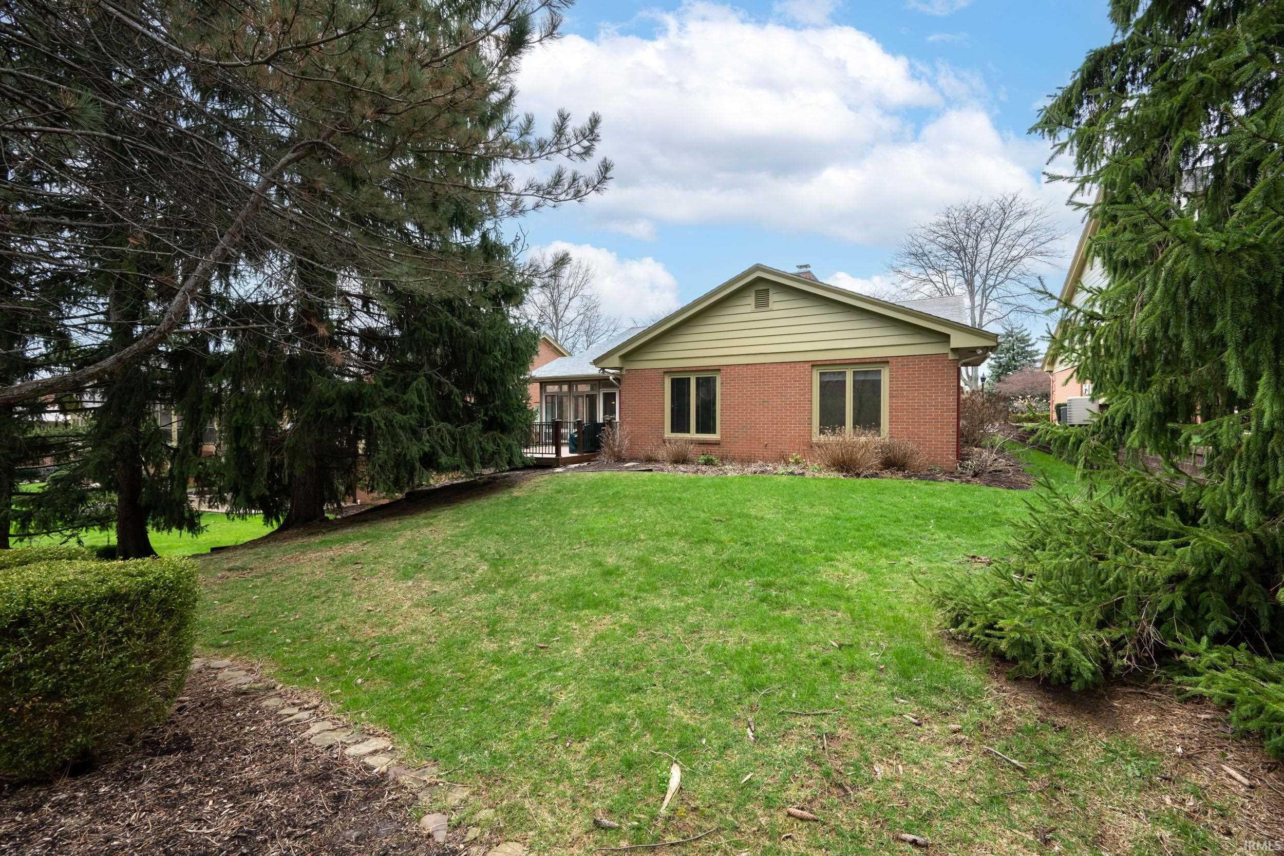 Rear view of house with a yard and brick siding