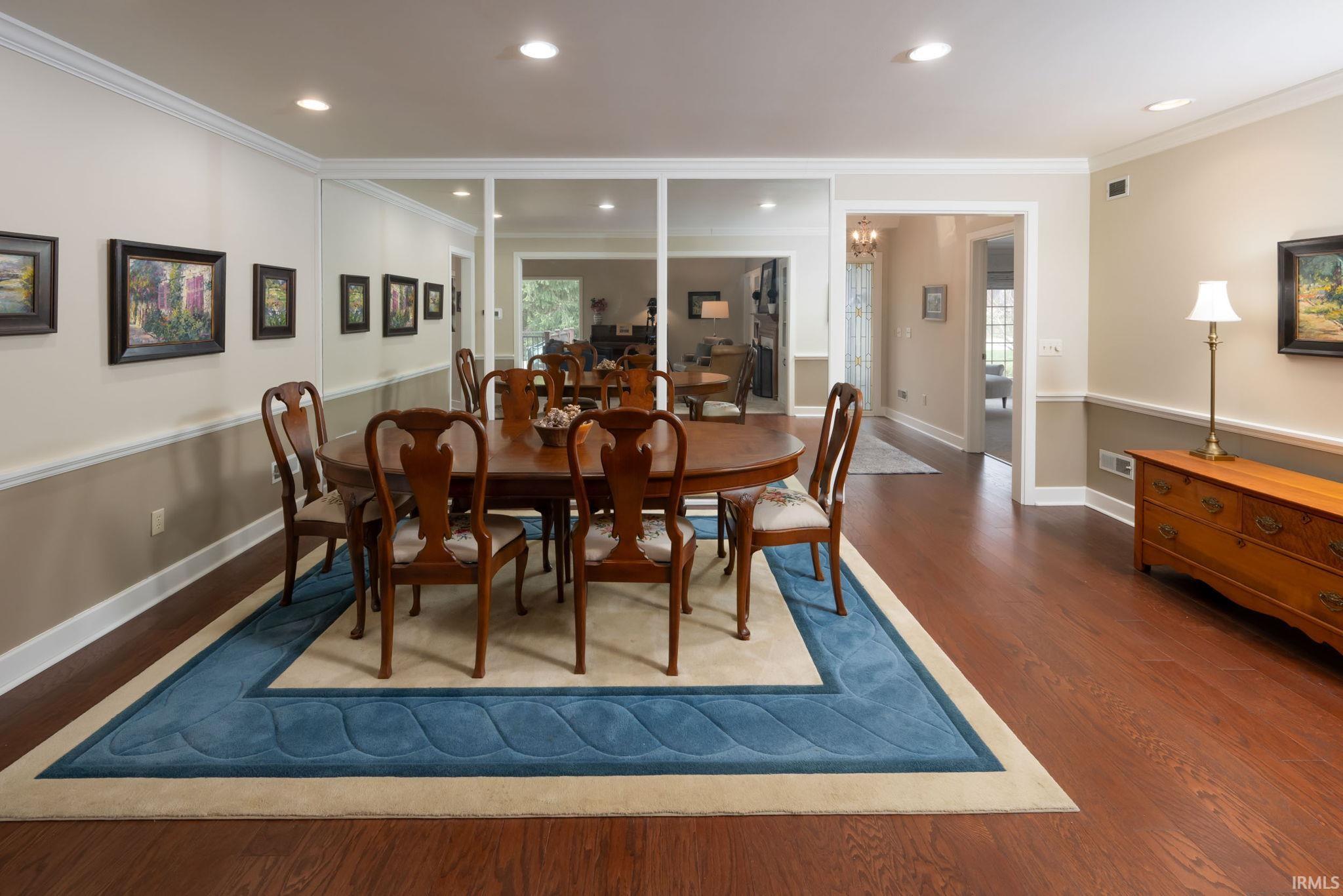 Dining area featuring wood finished floors, ornamental molding, and recessed lighting