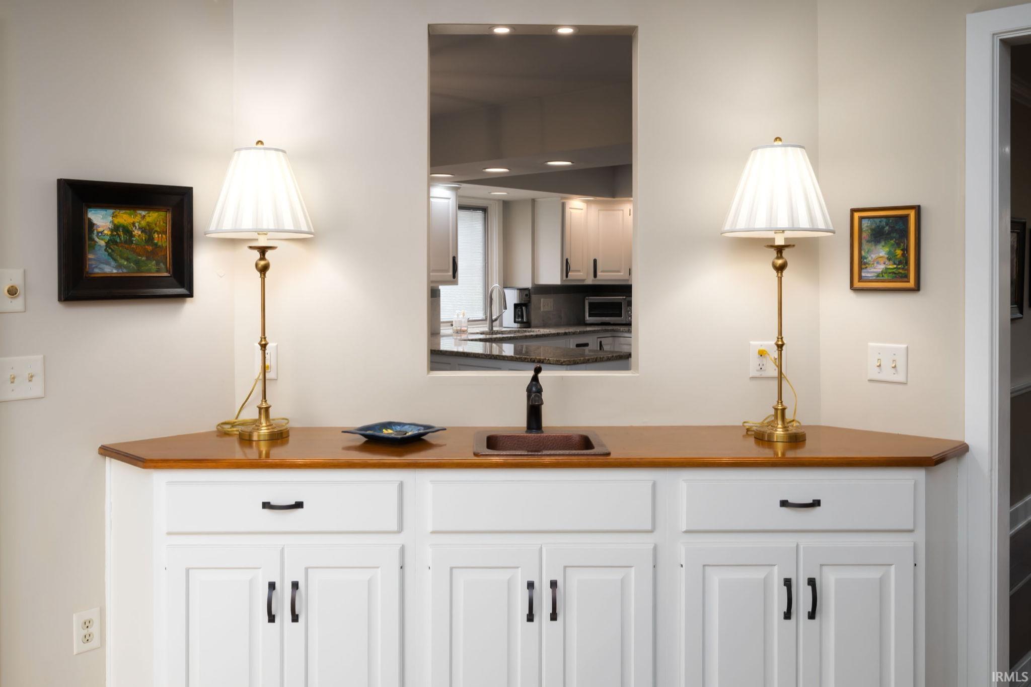 Bar area featuring white cabinetry and dark countertops