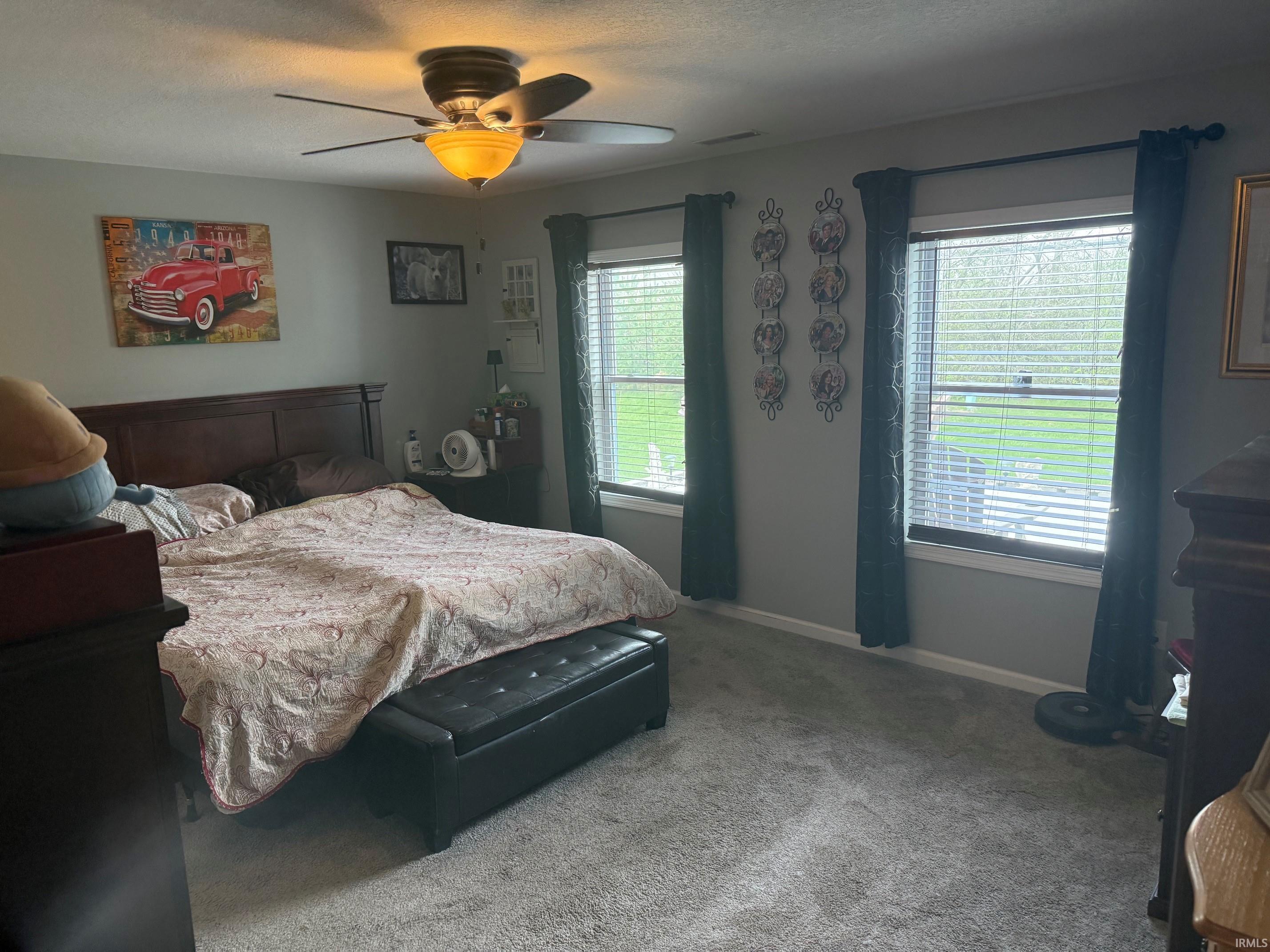 Bedroom featuring ceiling fan, carpet floors, and a textured ceiling