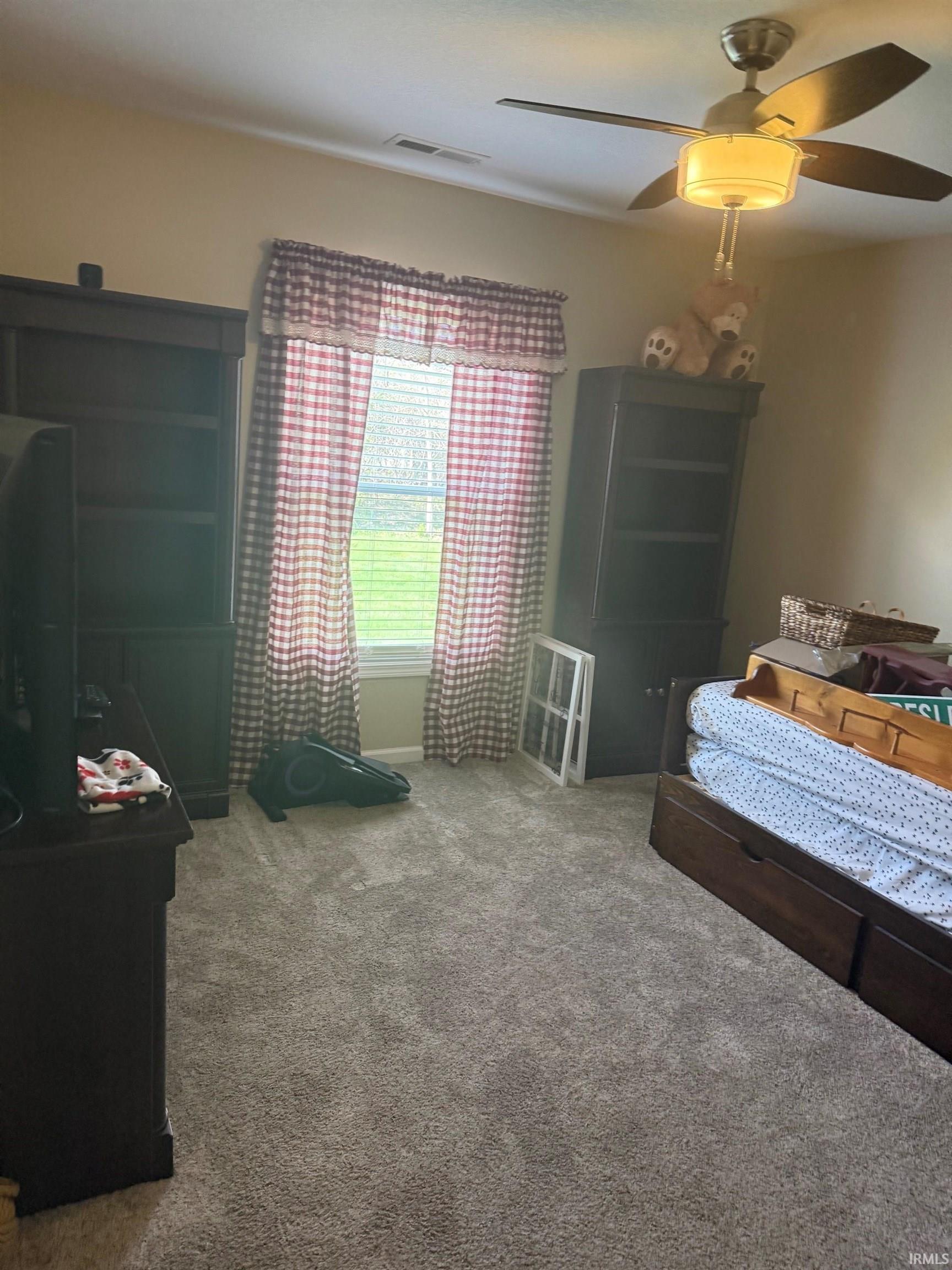 Bedroom featuring a ceiling fan and light colored carpet