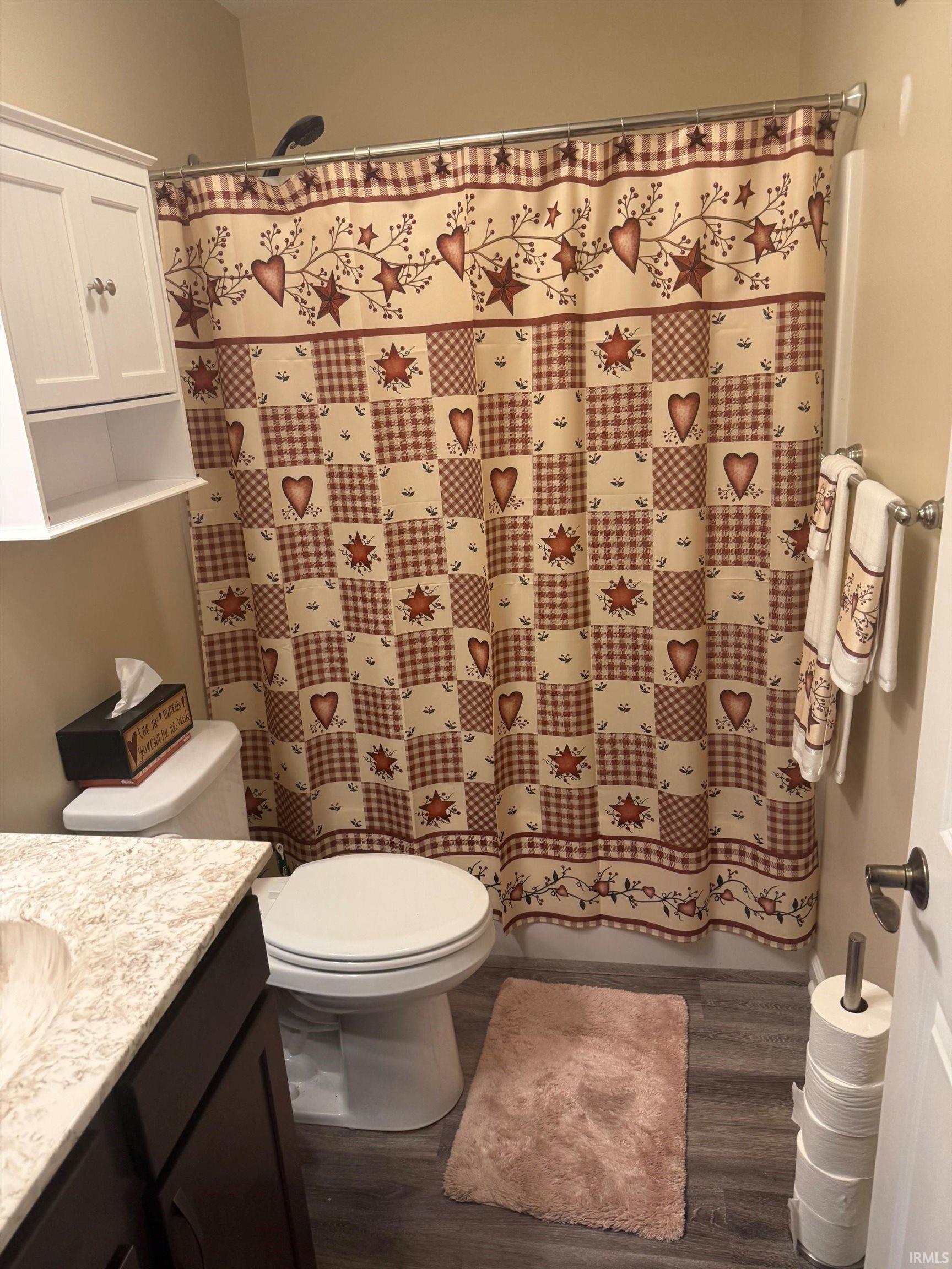 Bathroom with vanity, dark wood finished floors, and shower / bath combo