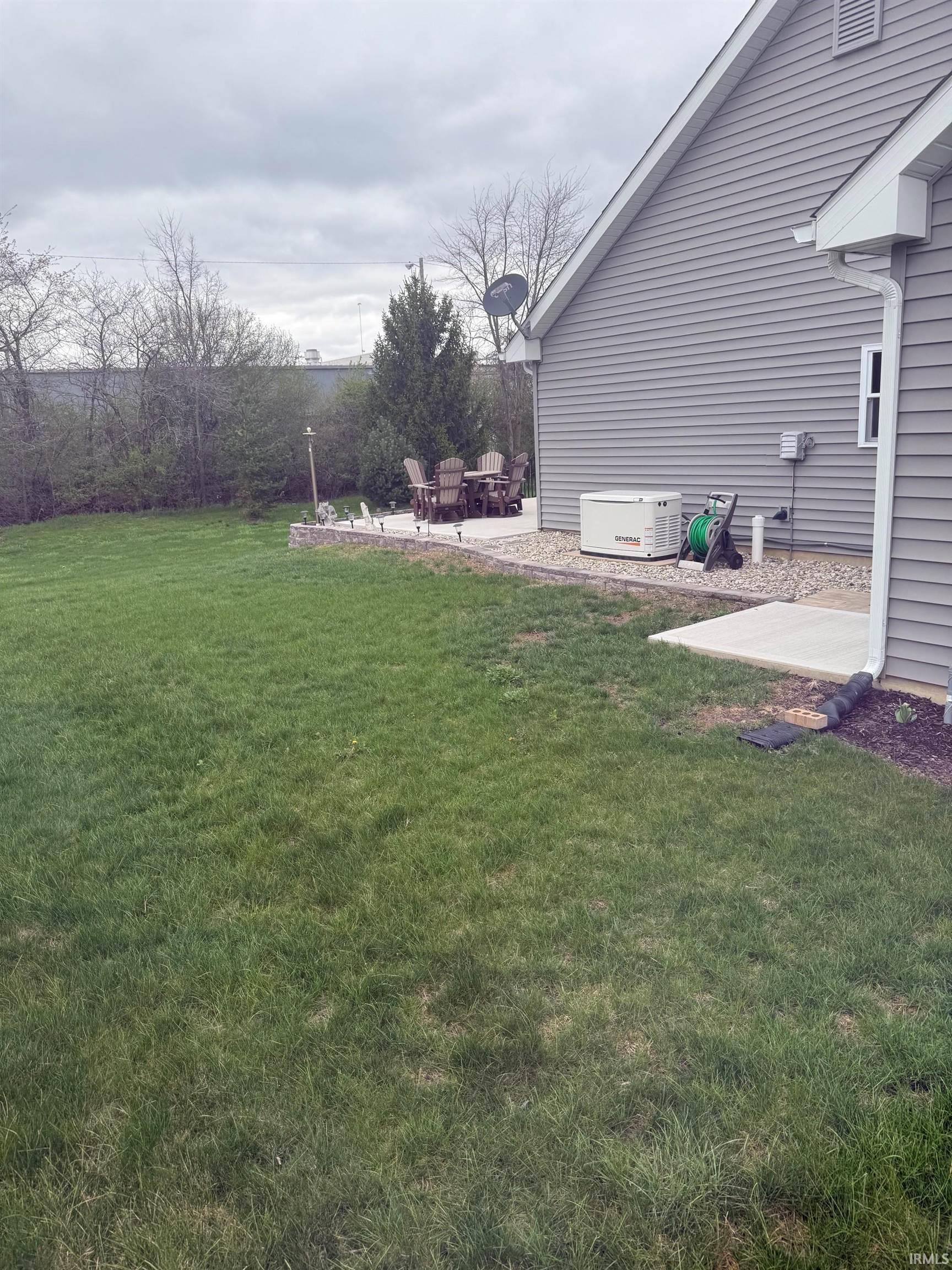 View of grassy yard featuring a patio