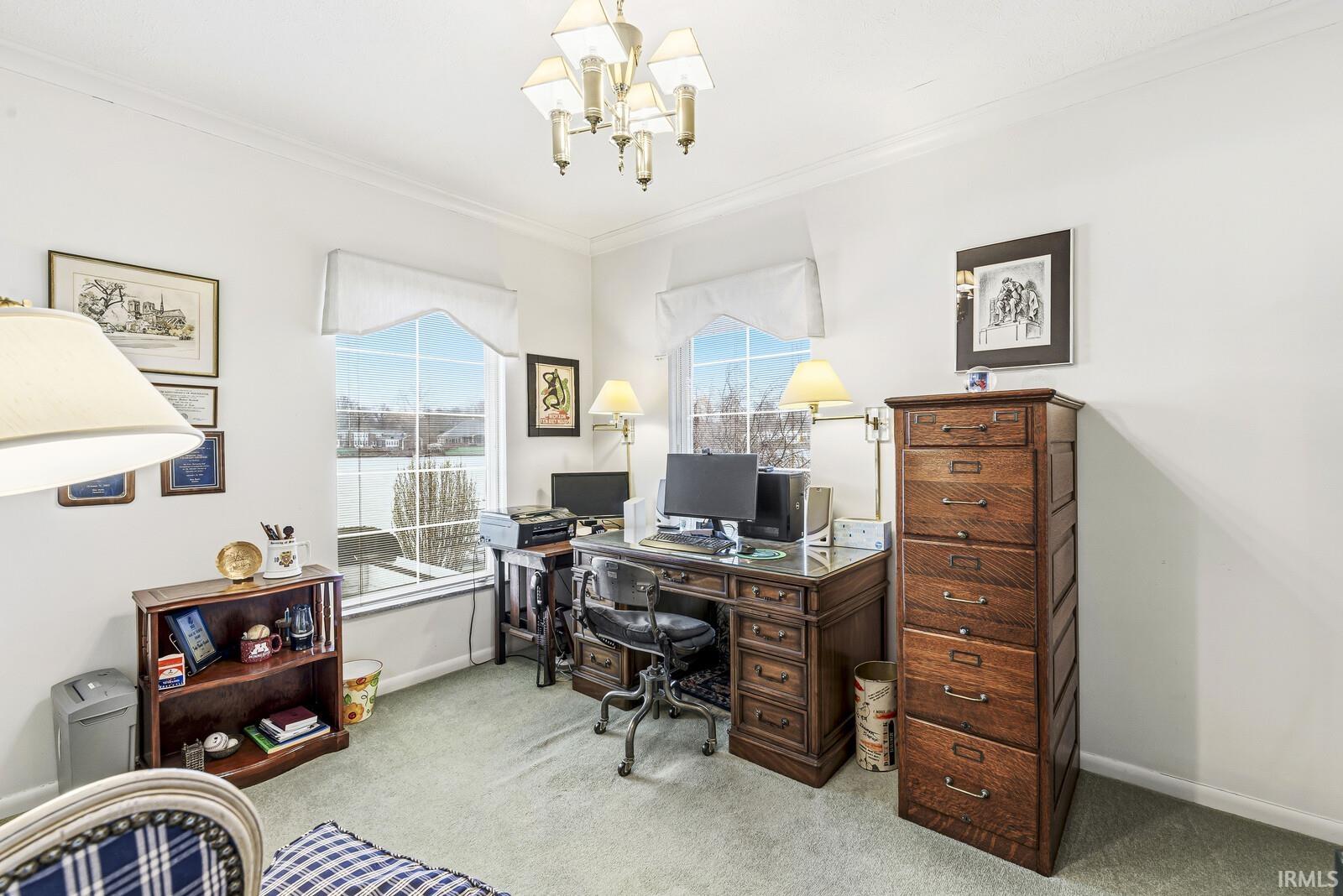 Office with light carpet, a chandelier, and ornamental molding