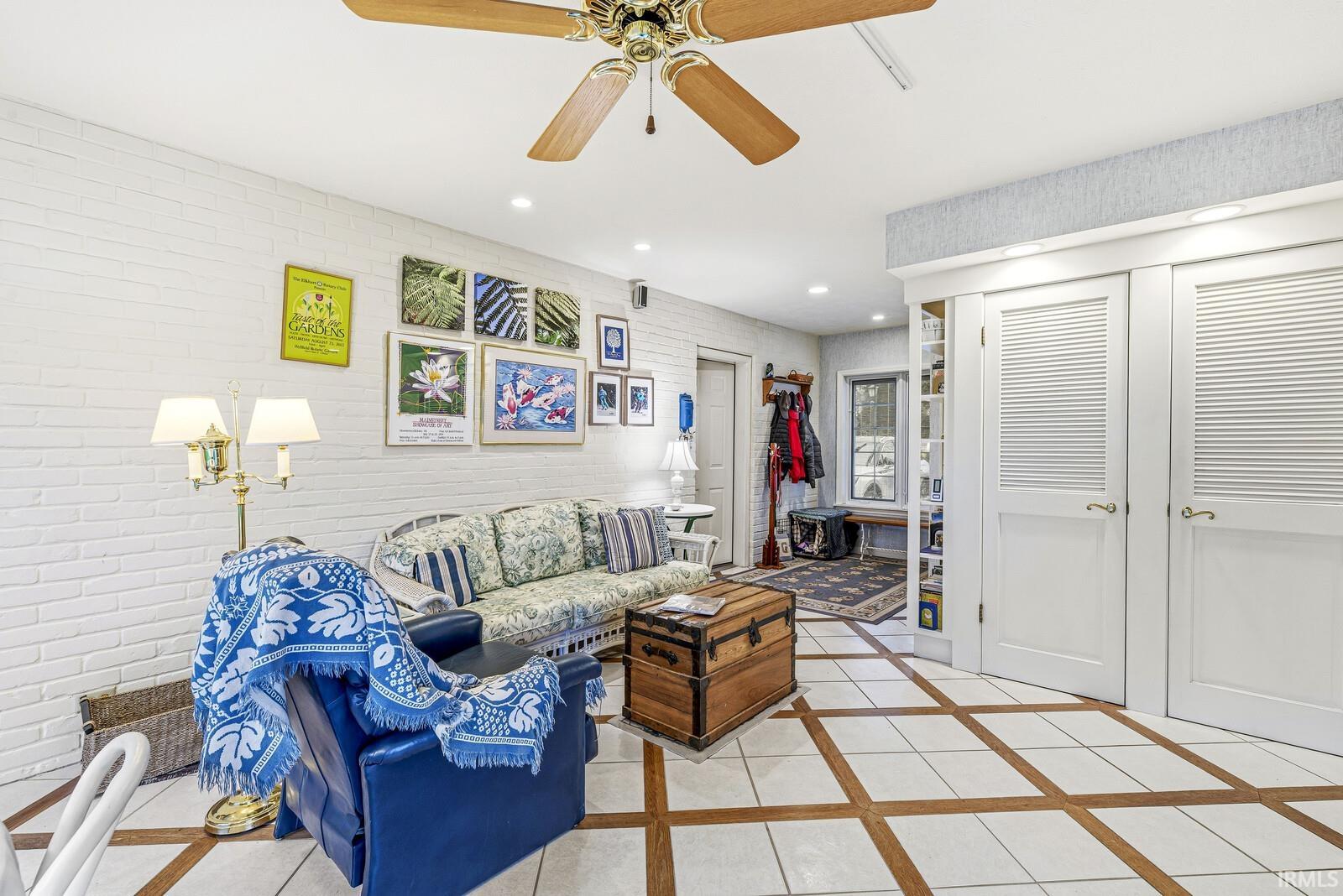 Living room with inlaid floor details, a ceiling fan, recessed lighting, and light tile patterned floors