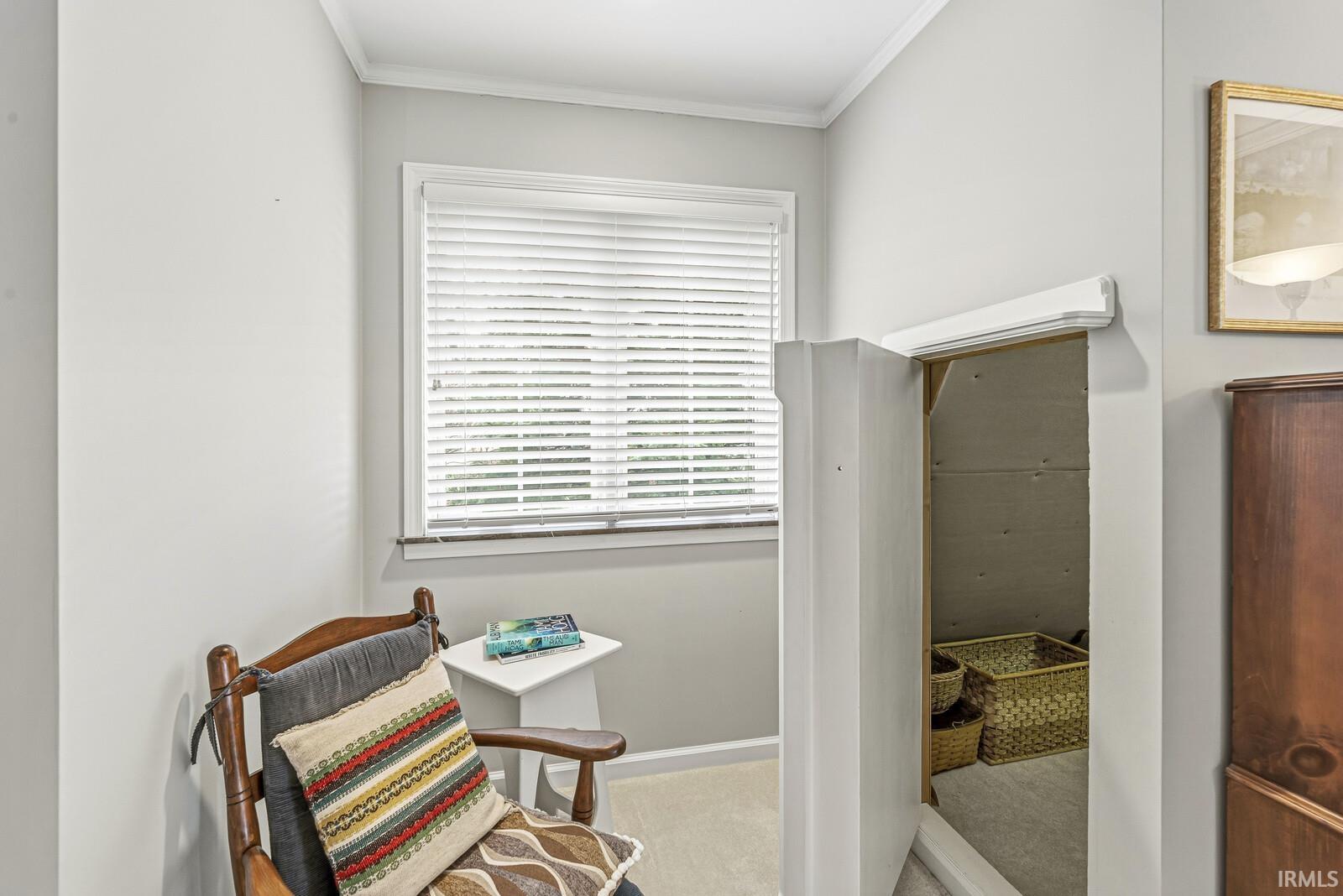 Living area with ornamental molding and light carpet