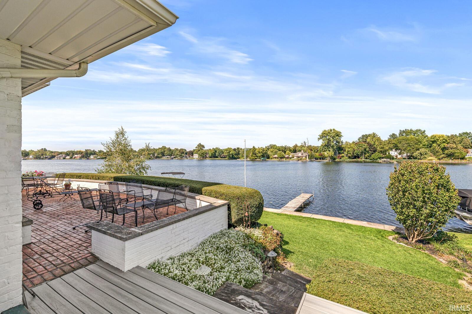 Wooden deck with a water view and a lawn
