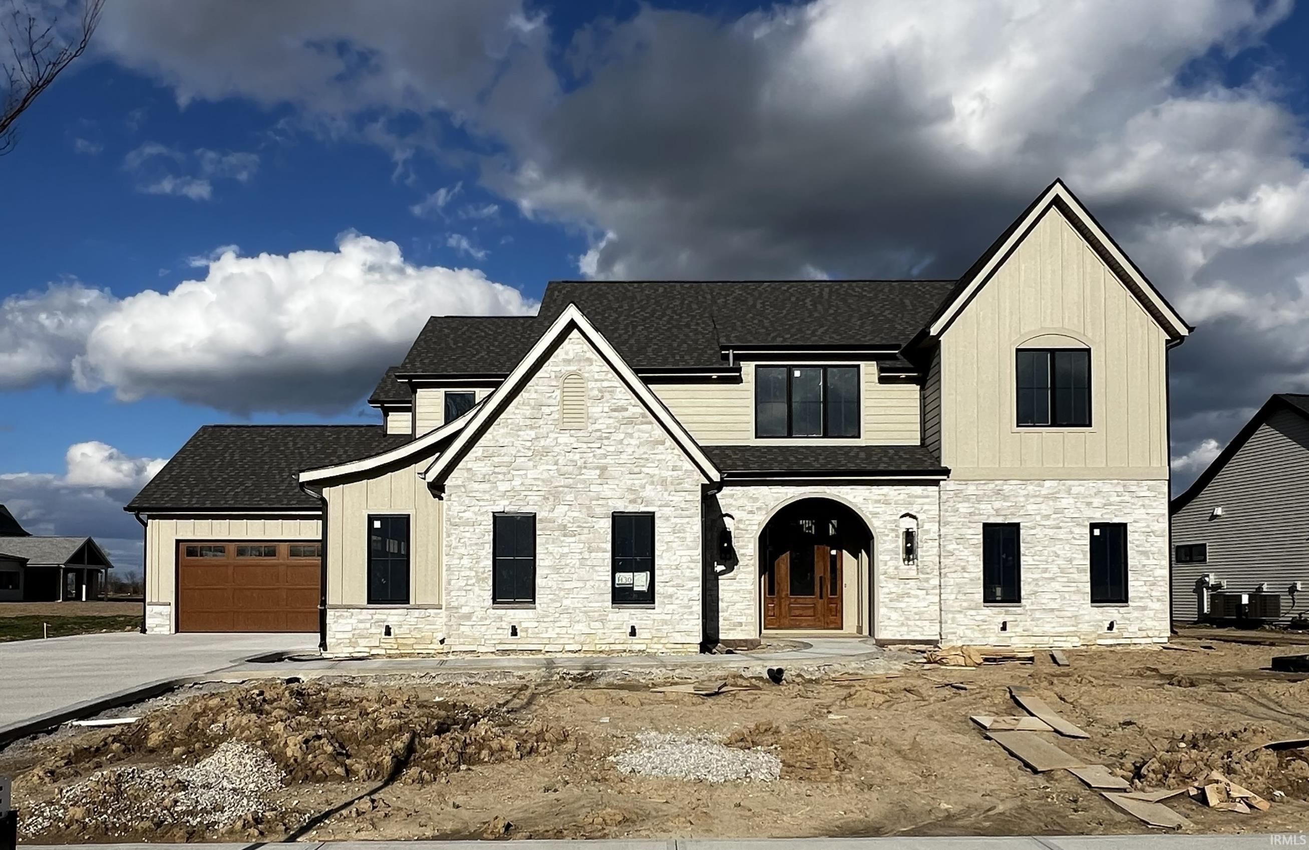 View of front of home featuring stone siding, a shingled roof, and an attached garage