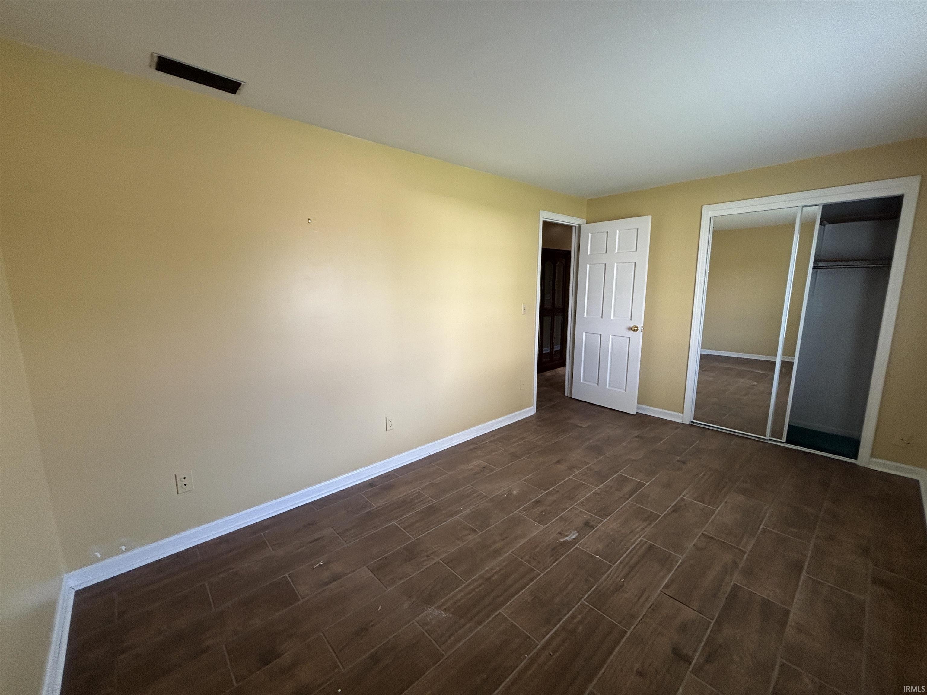 Unfurnished bedroom featuring a closet and wood finish floors