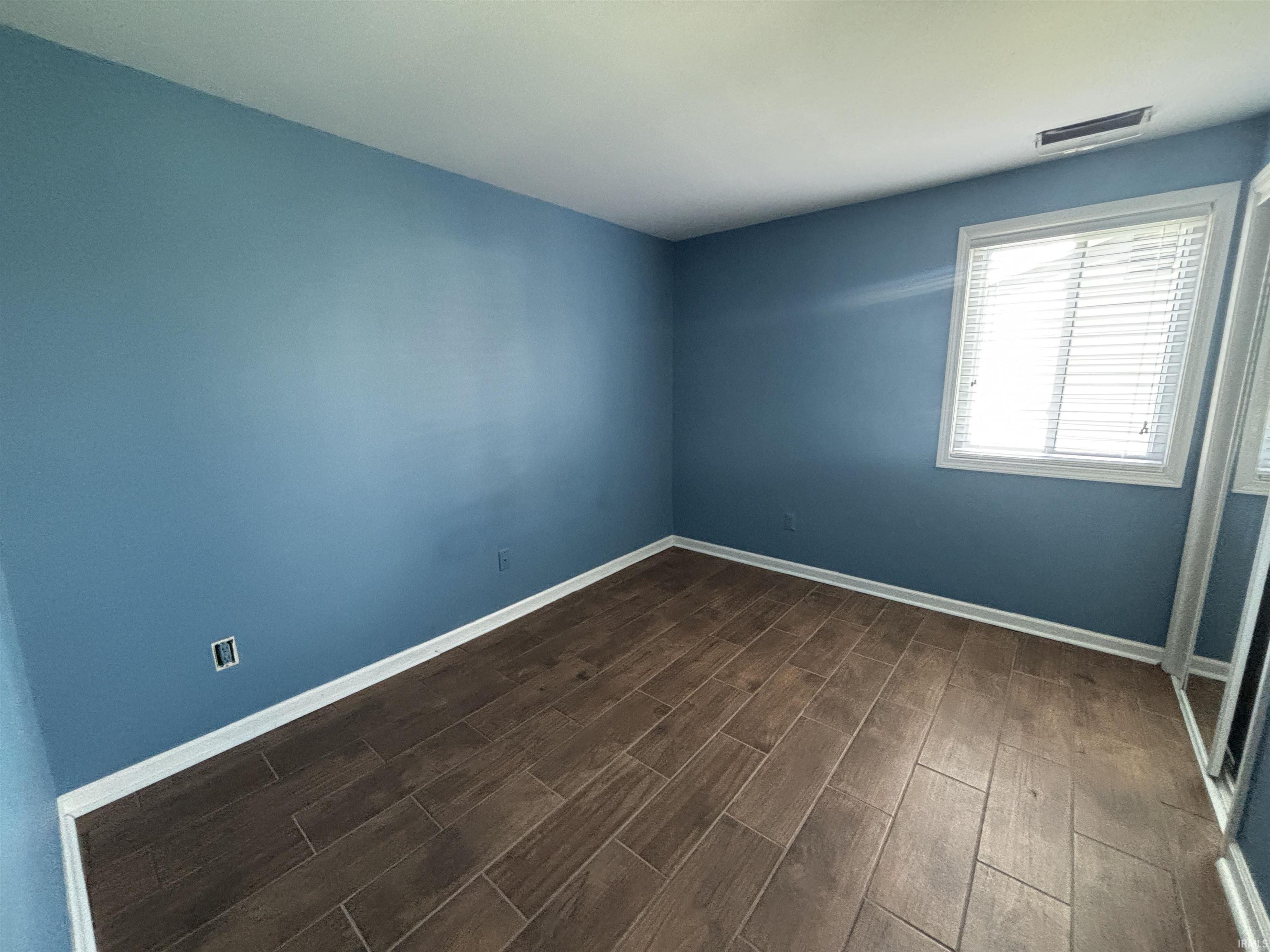Spare room with wood finish floors and baseboards
