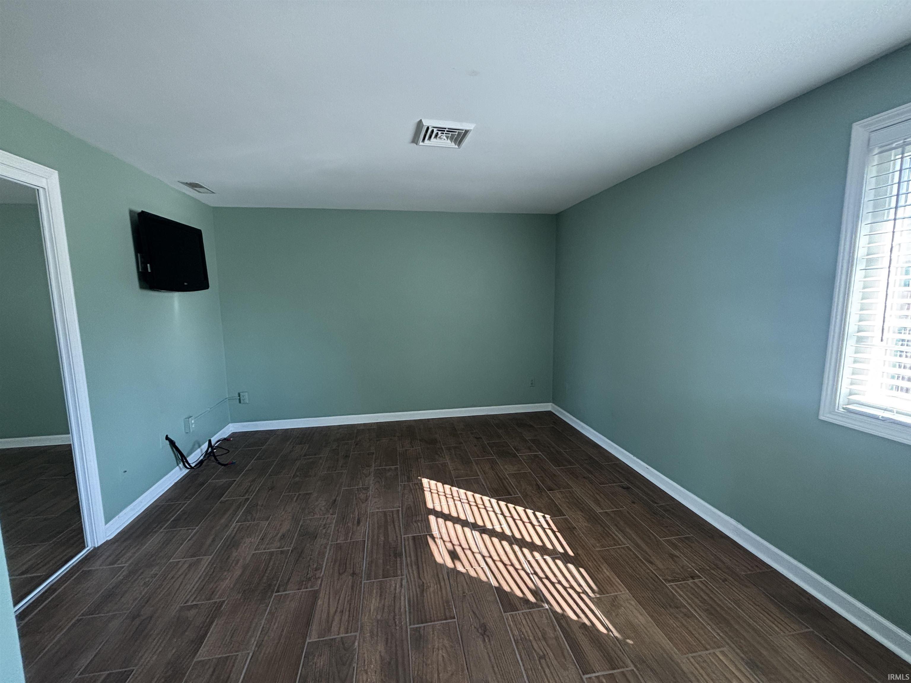 Spare room with wood tiled floors and baseboards