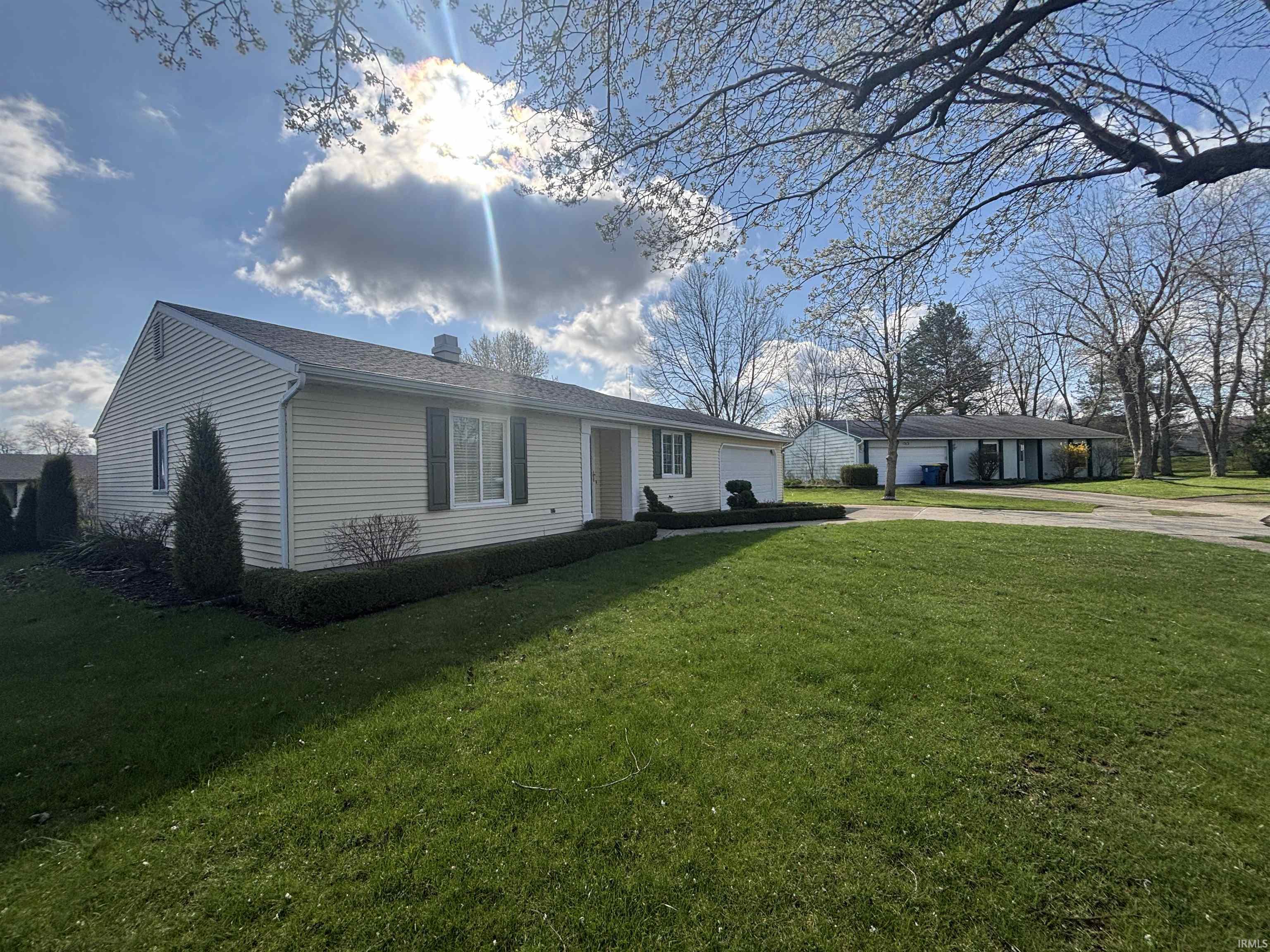 Single story home featuring a front yard, a garage, and driveway