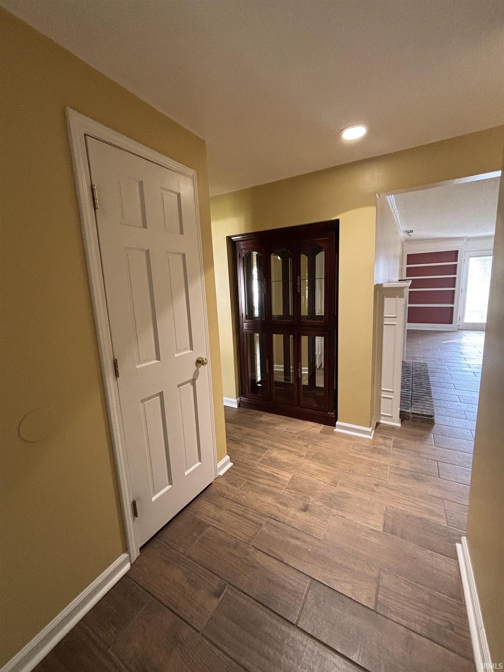 Corridor with dark wood-type flooring and recessed lighting