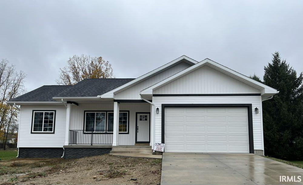Ranch-style house featuring covered porch, an attached garage, concrete driveway, and a shingled roof