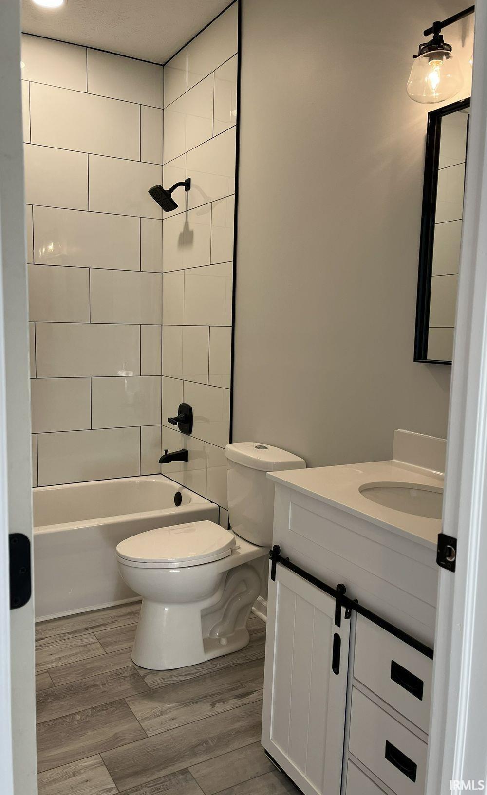 Bathroom with vanity, light wood-style flooring, and bathing tub / shower combination