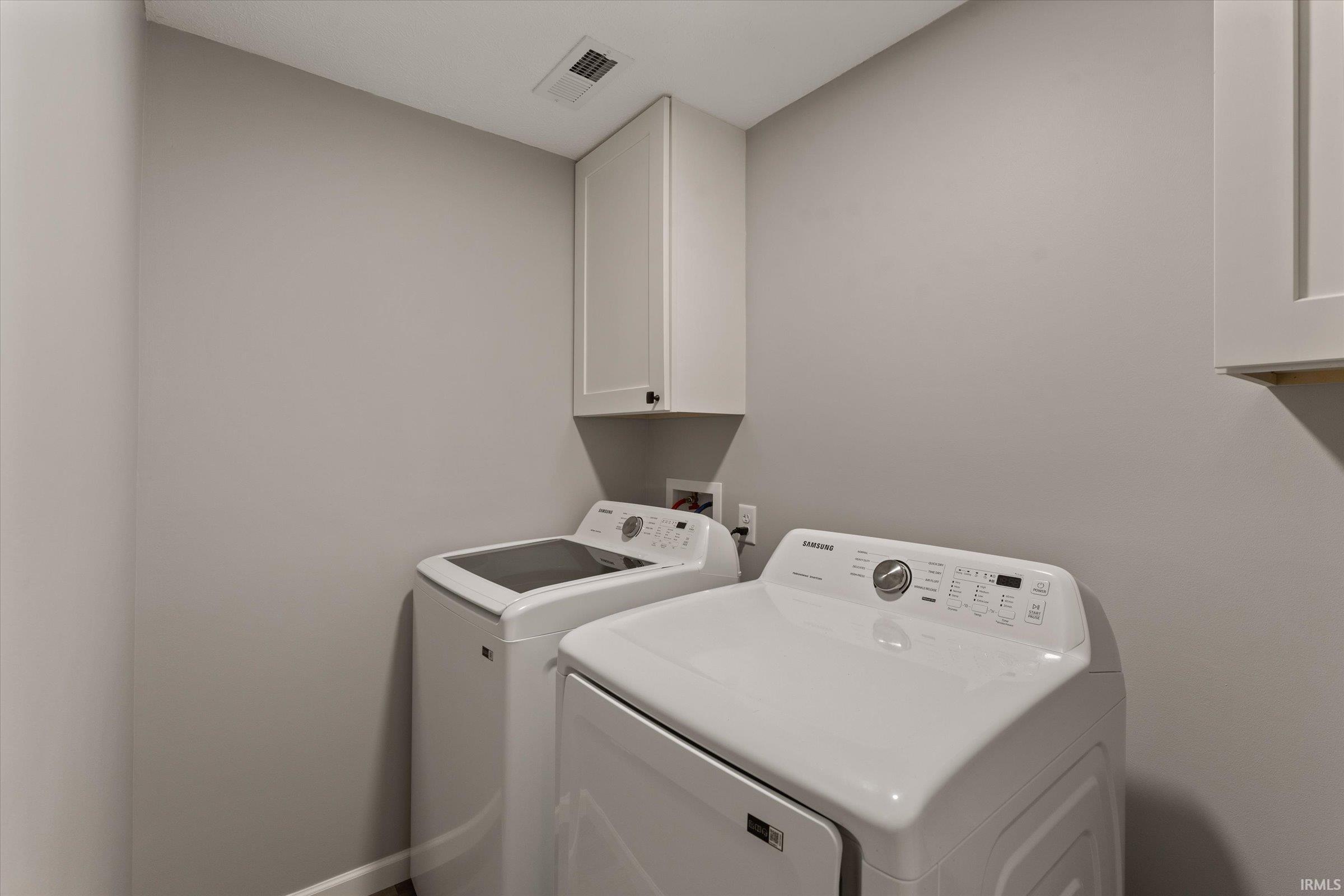 Laundry room featuring cabinet space and washing machine and clothes dryer