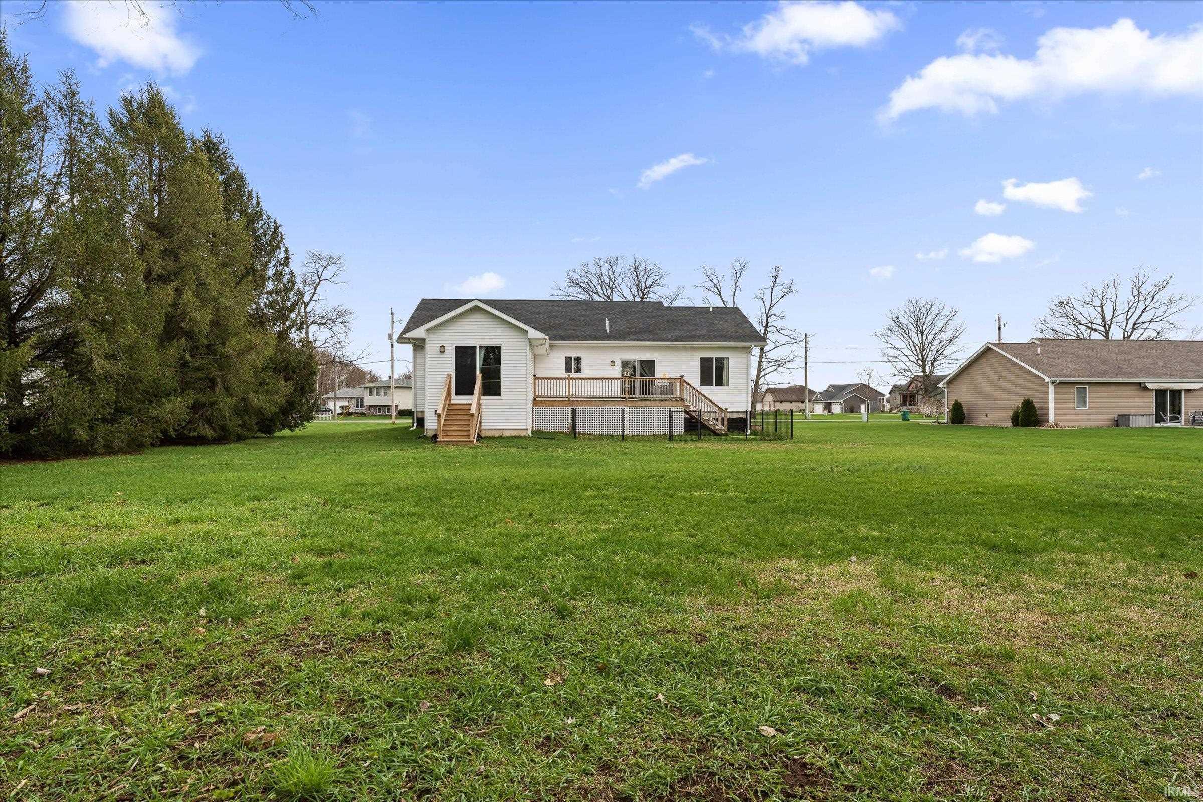 Rear view of house featuring a yard and a deck
