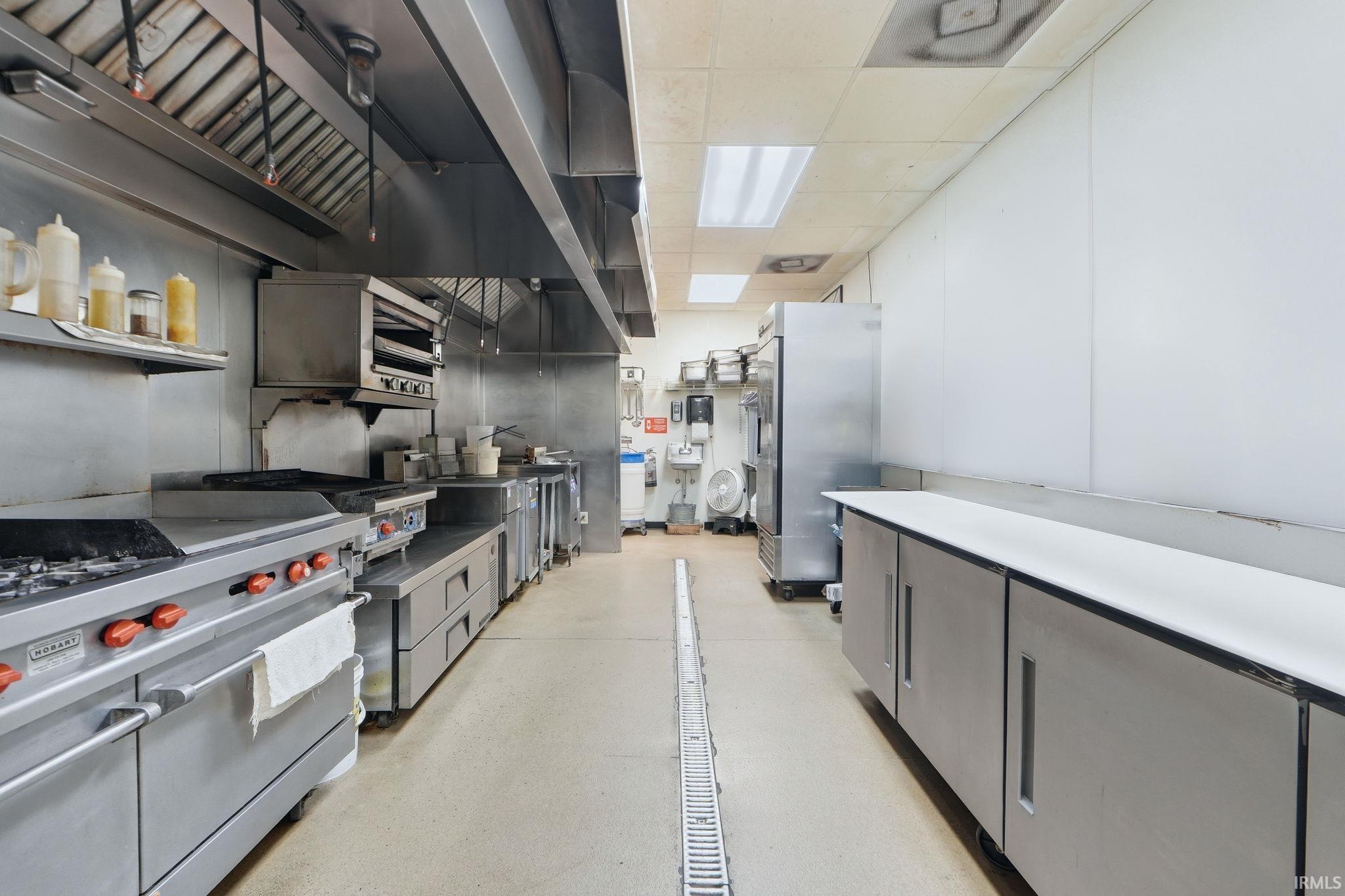 Kitchen with freestanding refrigerator, gray cabinets, light countertops, and a paneled ceiling