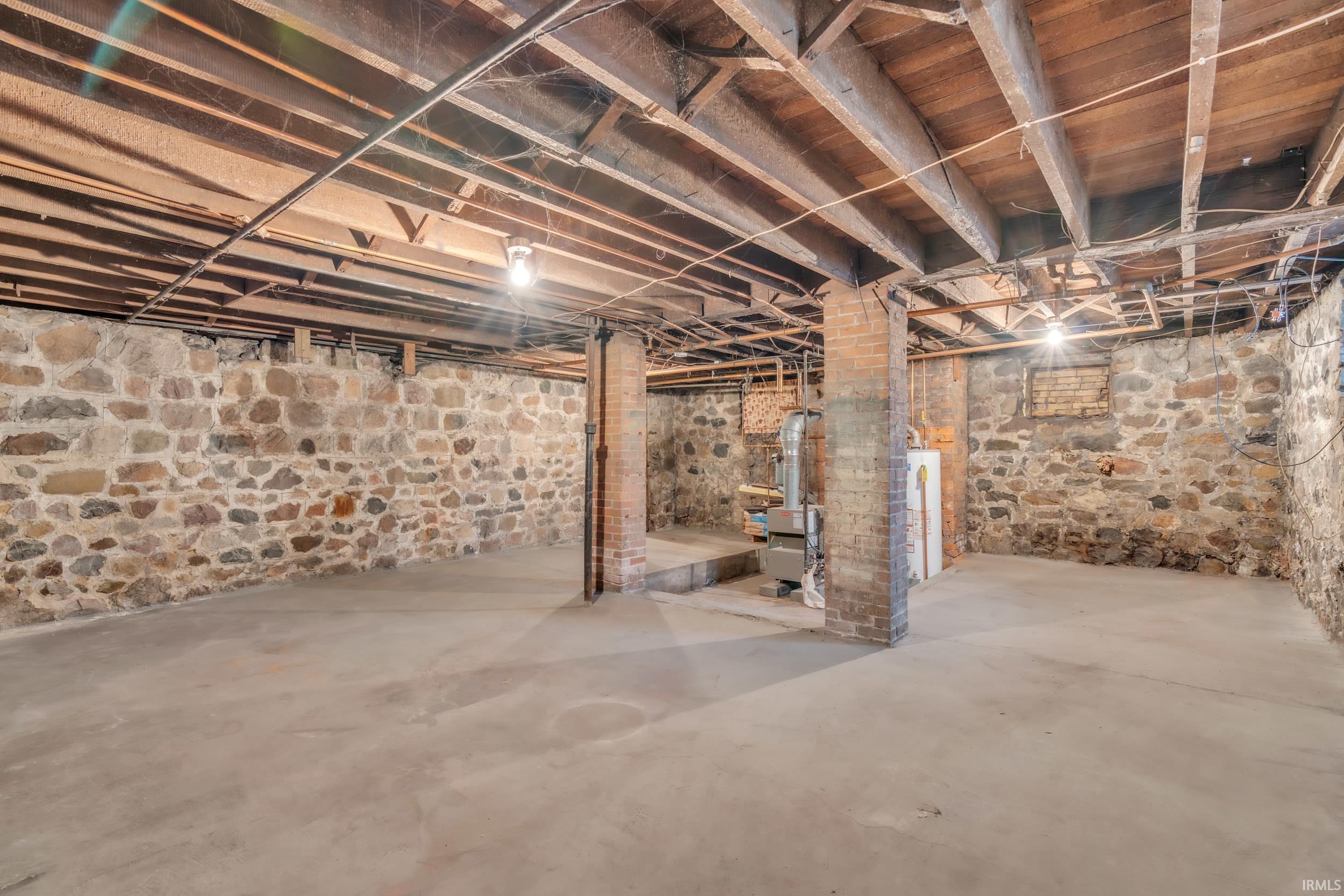 Unfinished below grade area featuring water heater