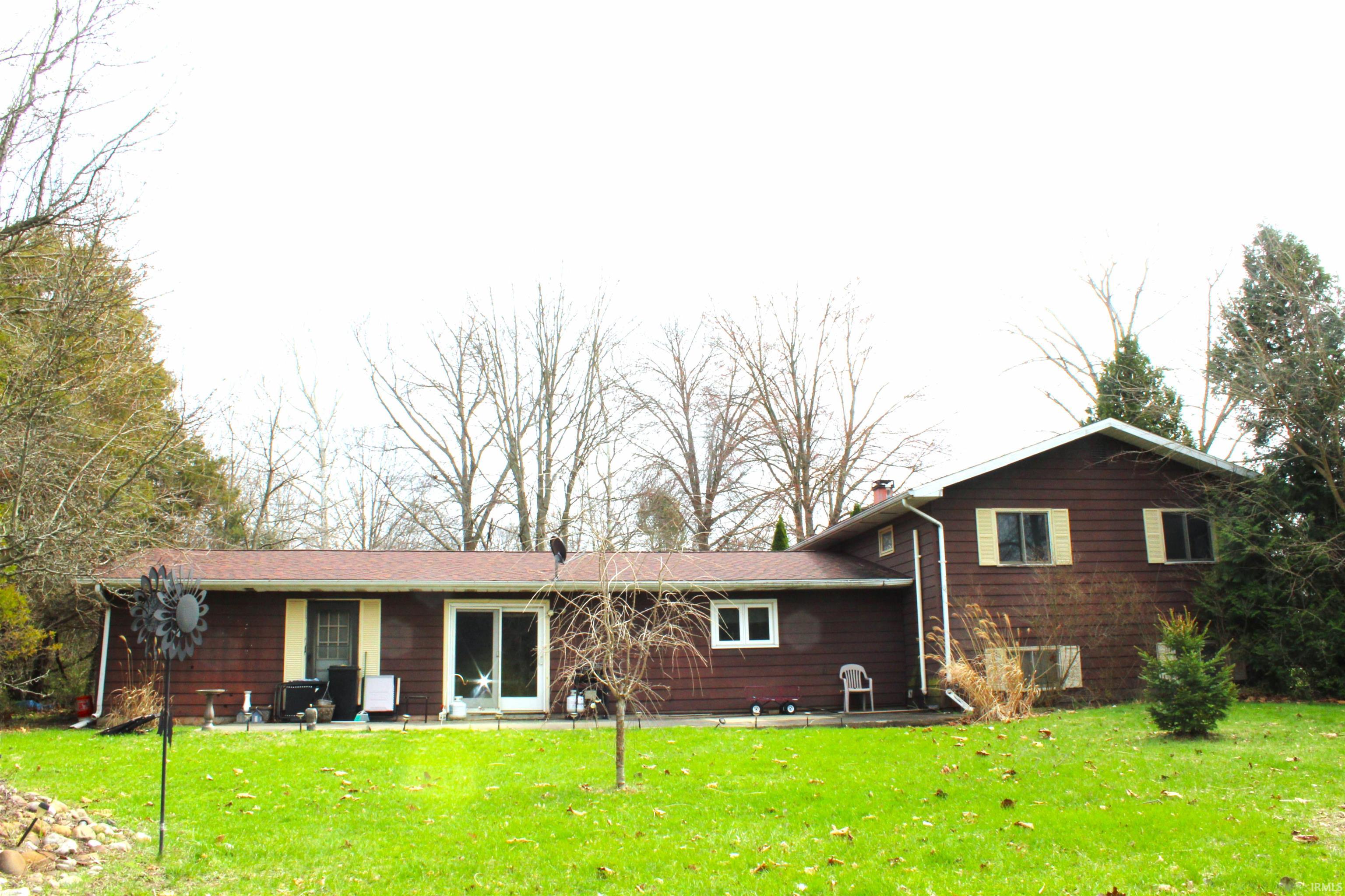 Rear view of house with a yard and a chimney