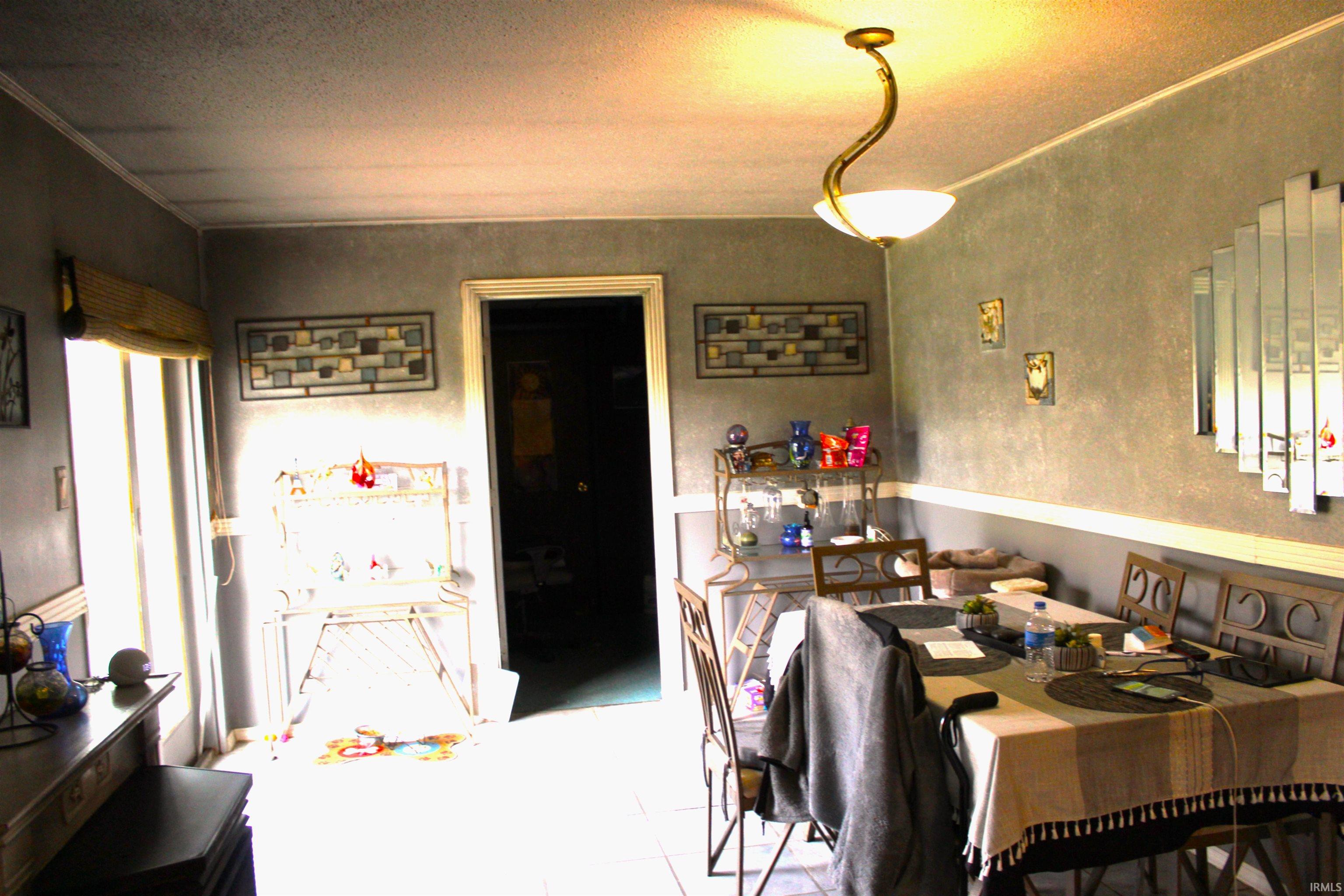 Dining room with light tile patterned flooring and a textured ceiling