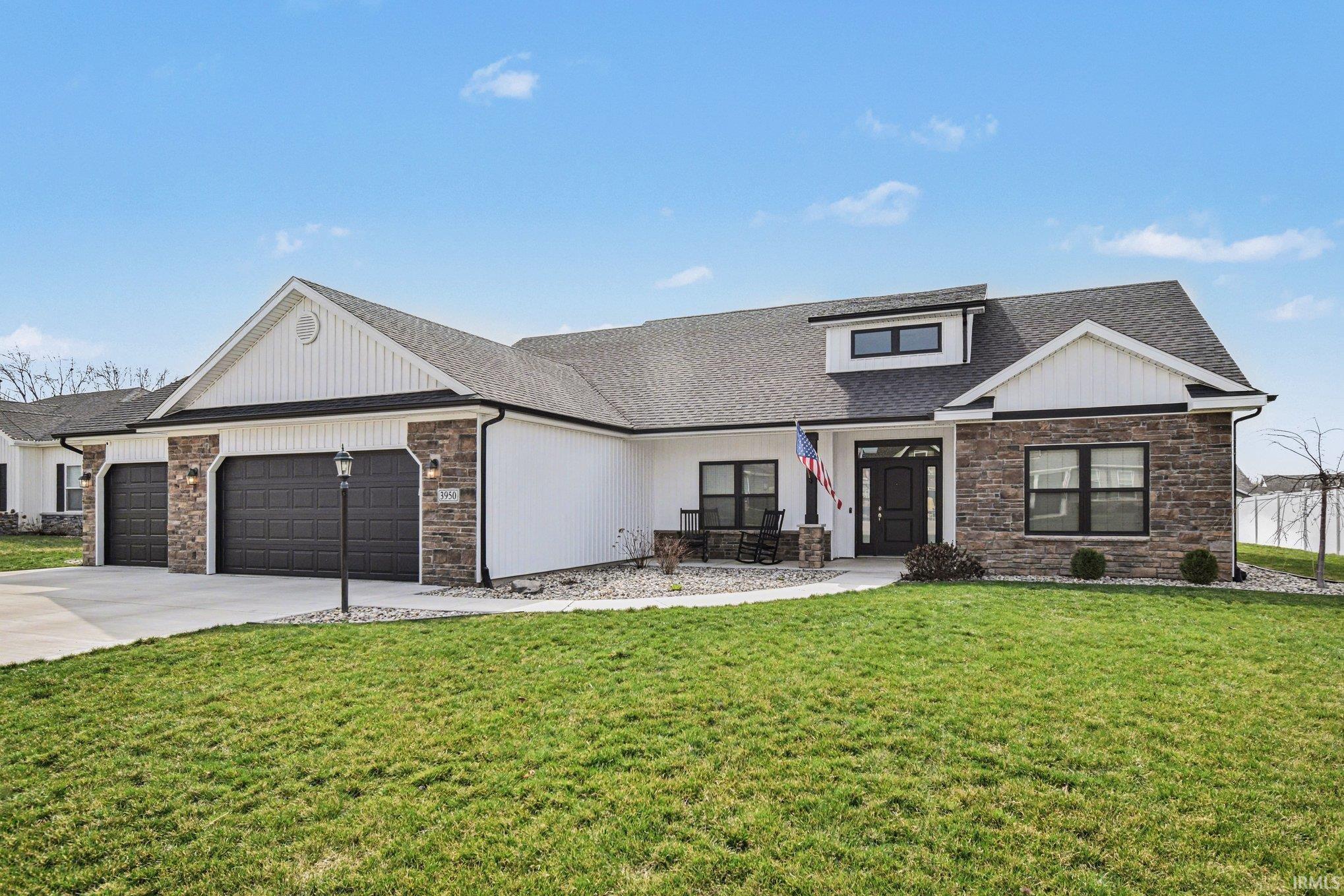 View of front of home with stone siding, an attached garage, and roof with shingles