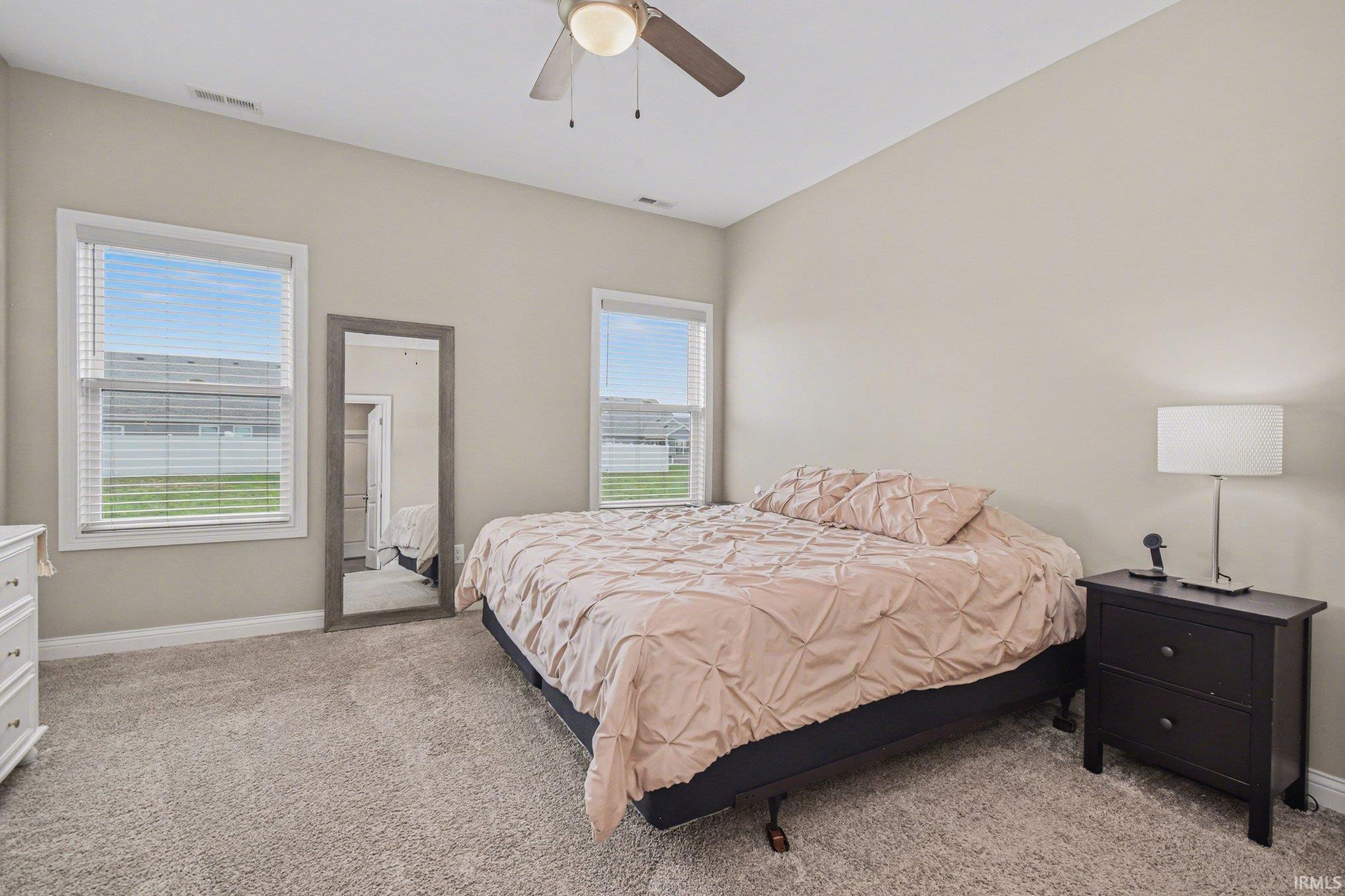Bedroom featuring light colored carpet and a ceiling fan