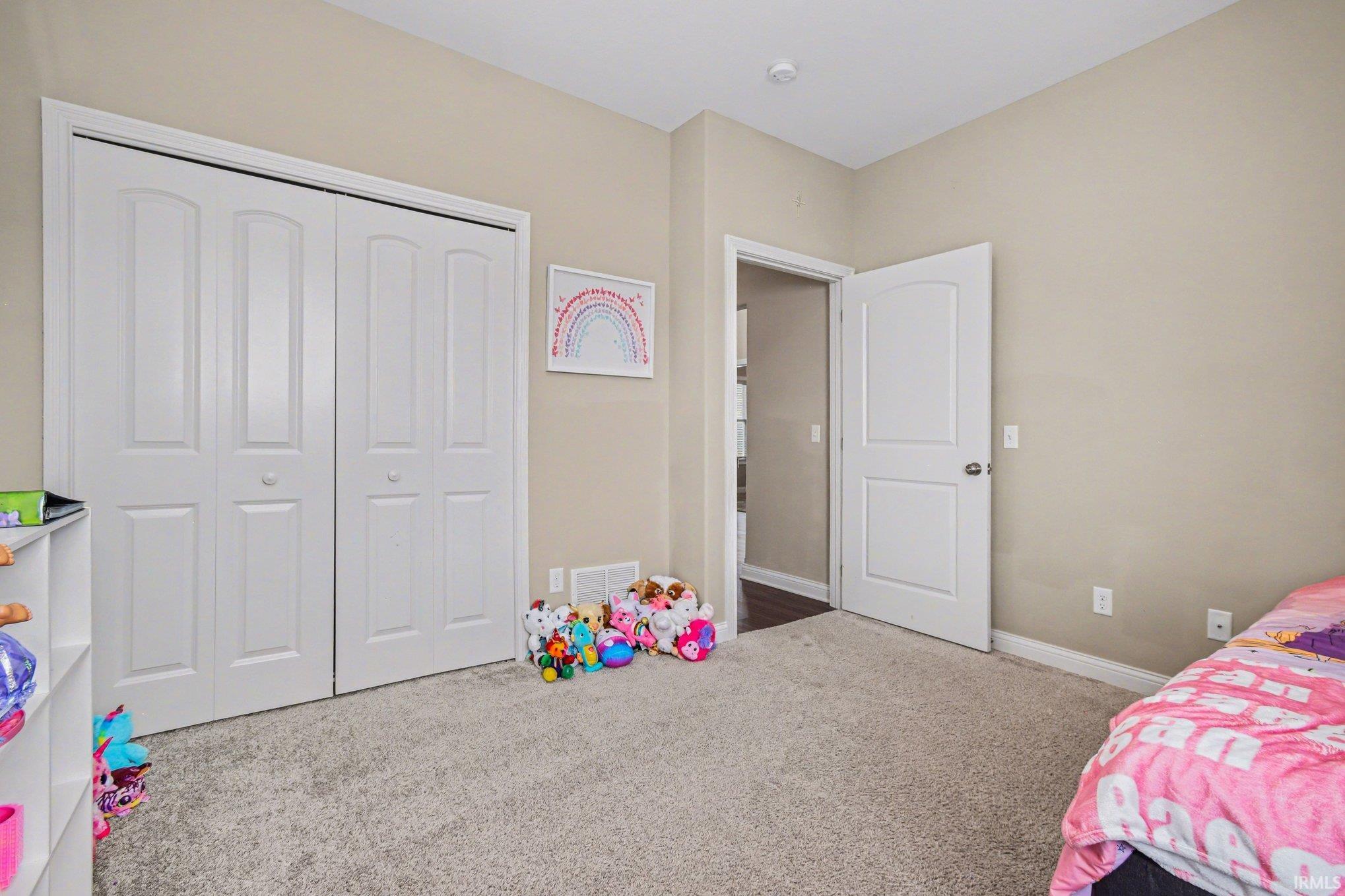 Bedroom featuring carpet and a closet