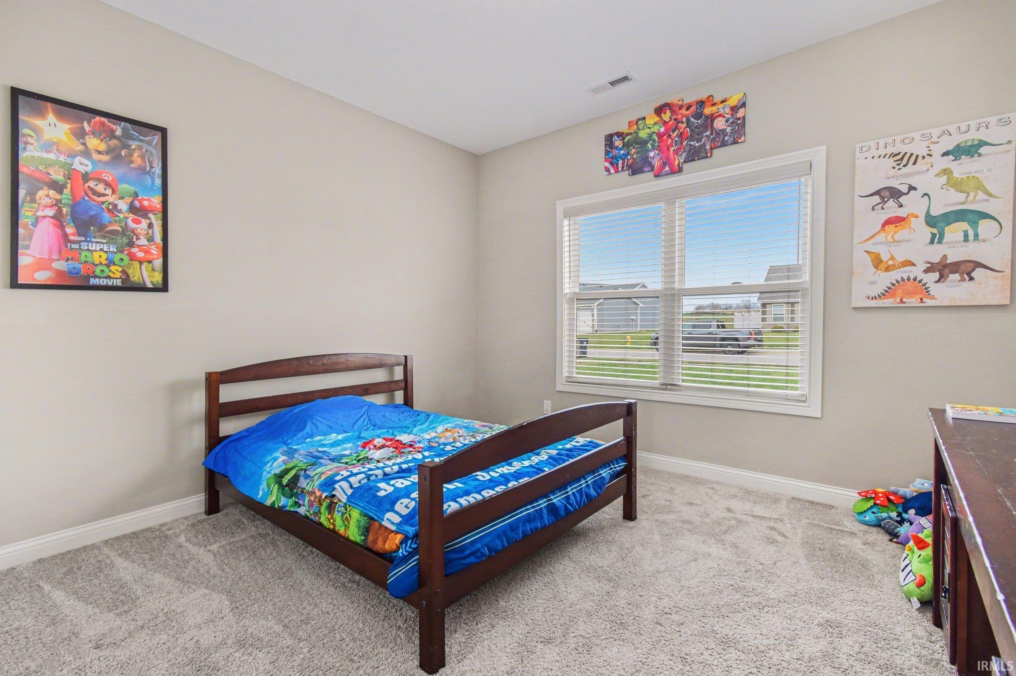 Bedroom featuring light colored carpet and baseboards