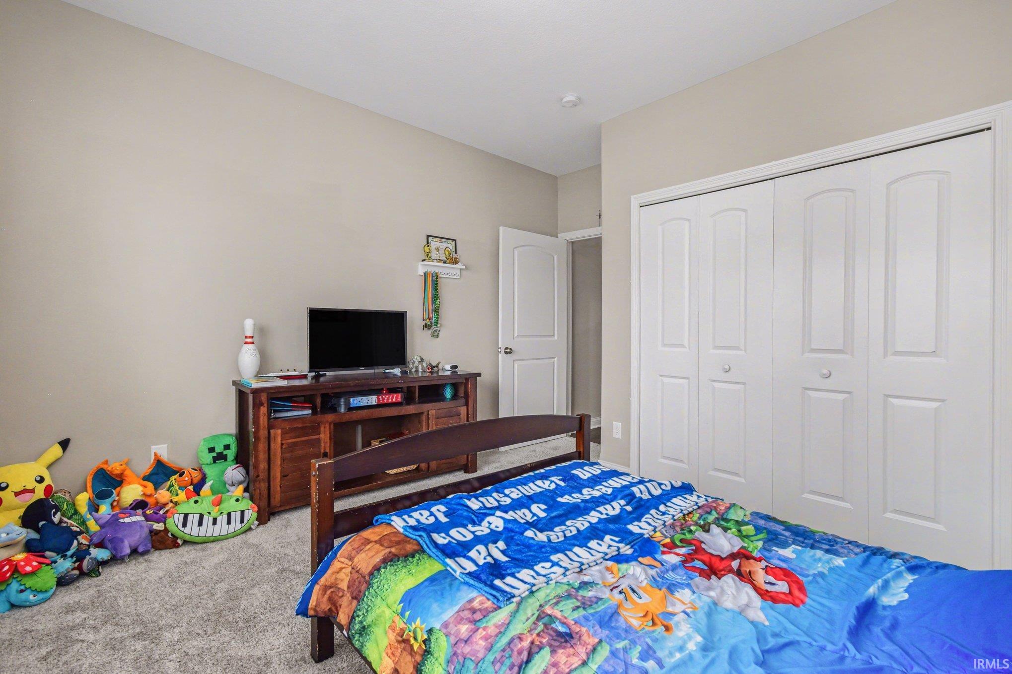 Carpeted bedroom with a closet