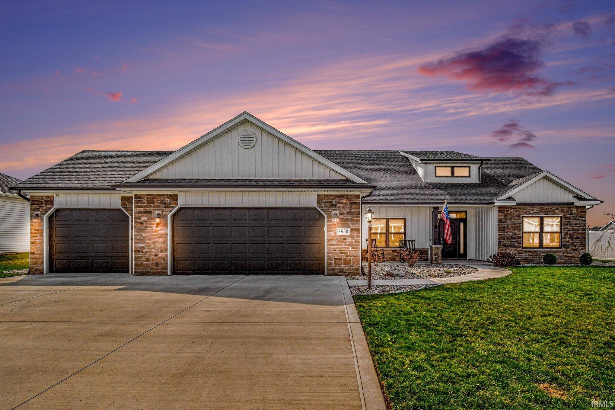 View of front of home with an attached garage, covered porch, concrete driveway, and roof with shingles