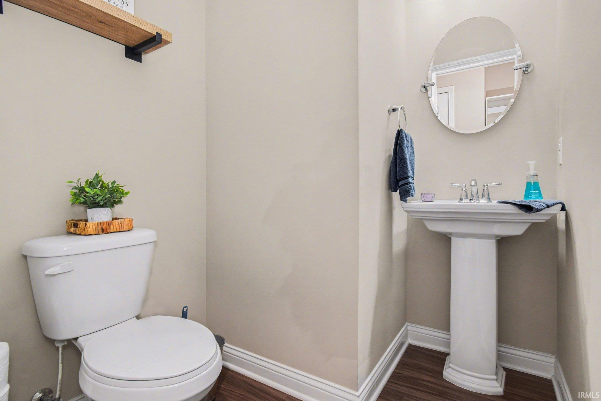 Half bath featuring baseboards and dark wood-style floors
