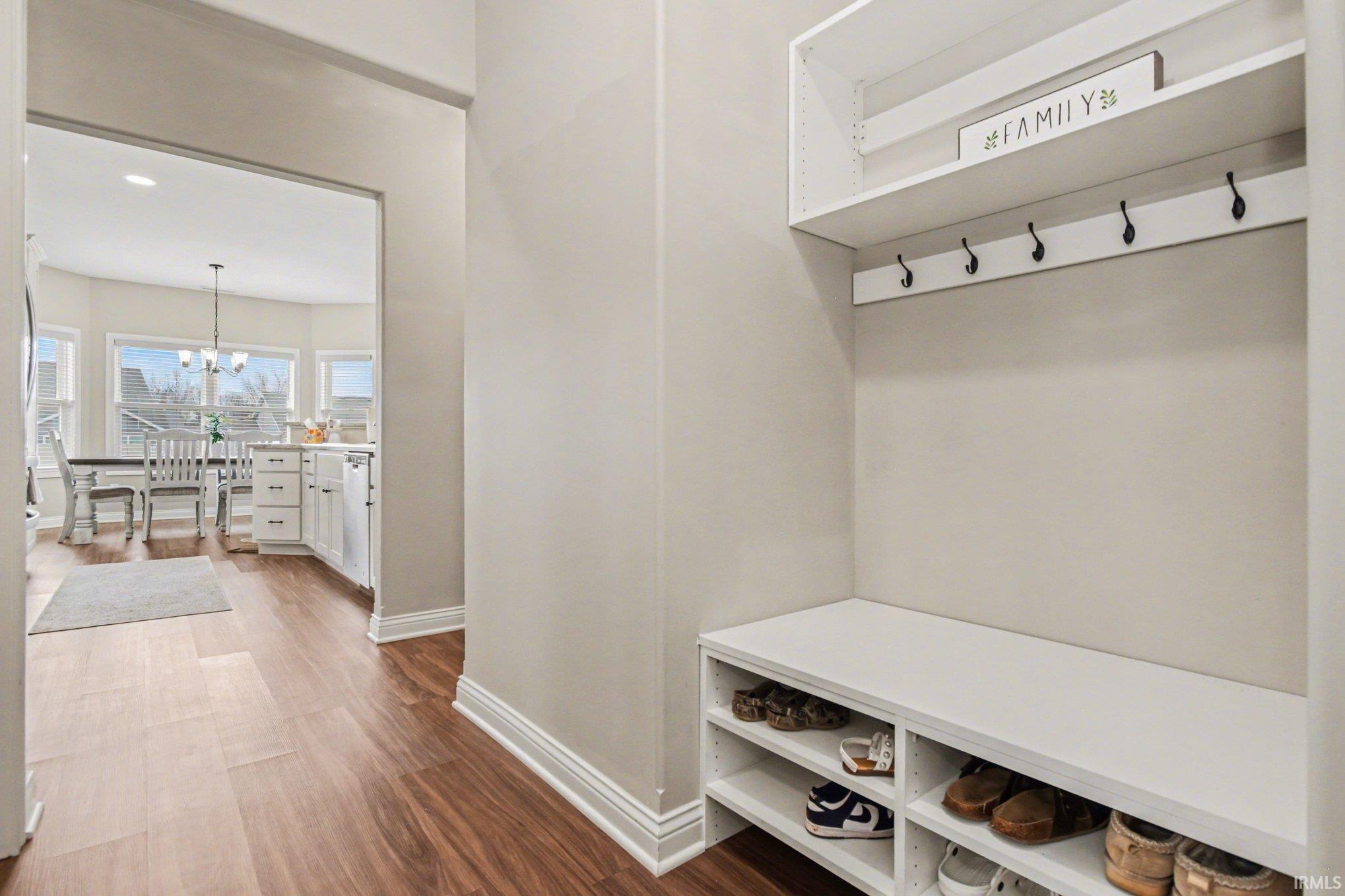 Mudroom with dark wood finished floors and hanging lights