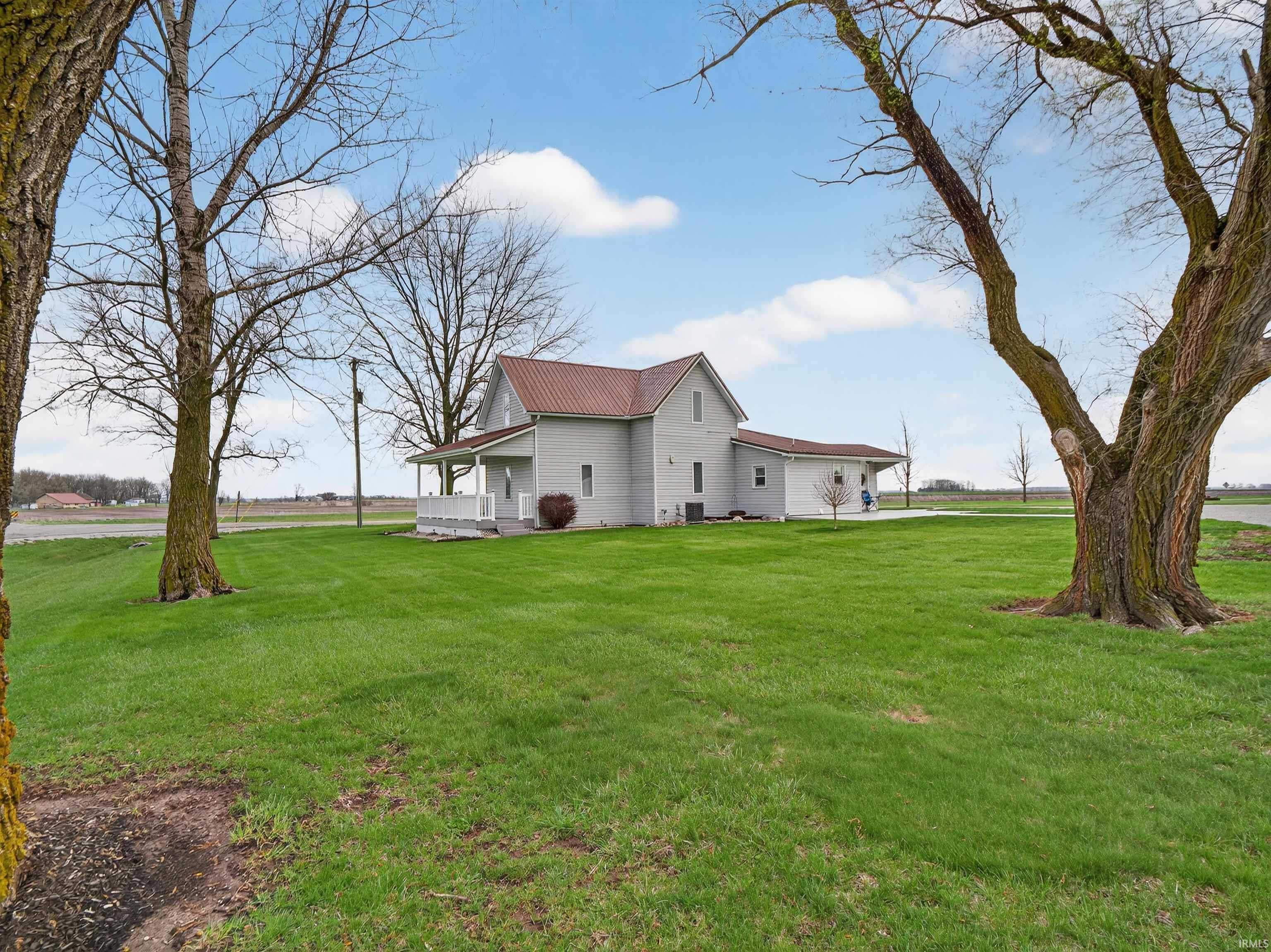 View of home's exterior featuring covered porch, a yard, and a metal roof